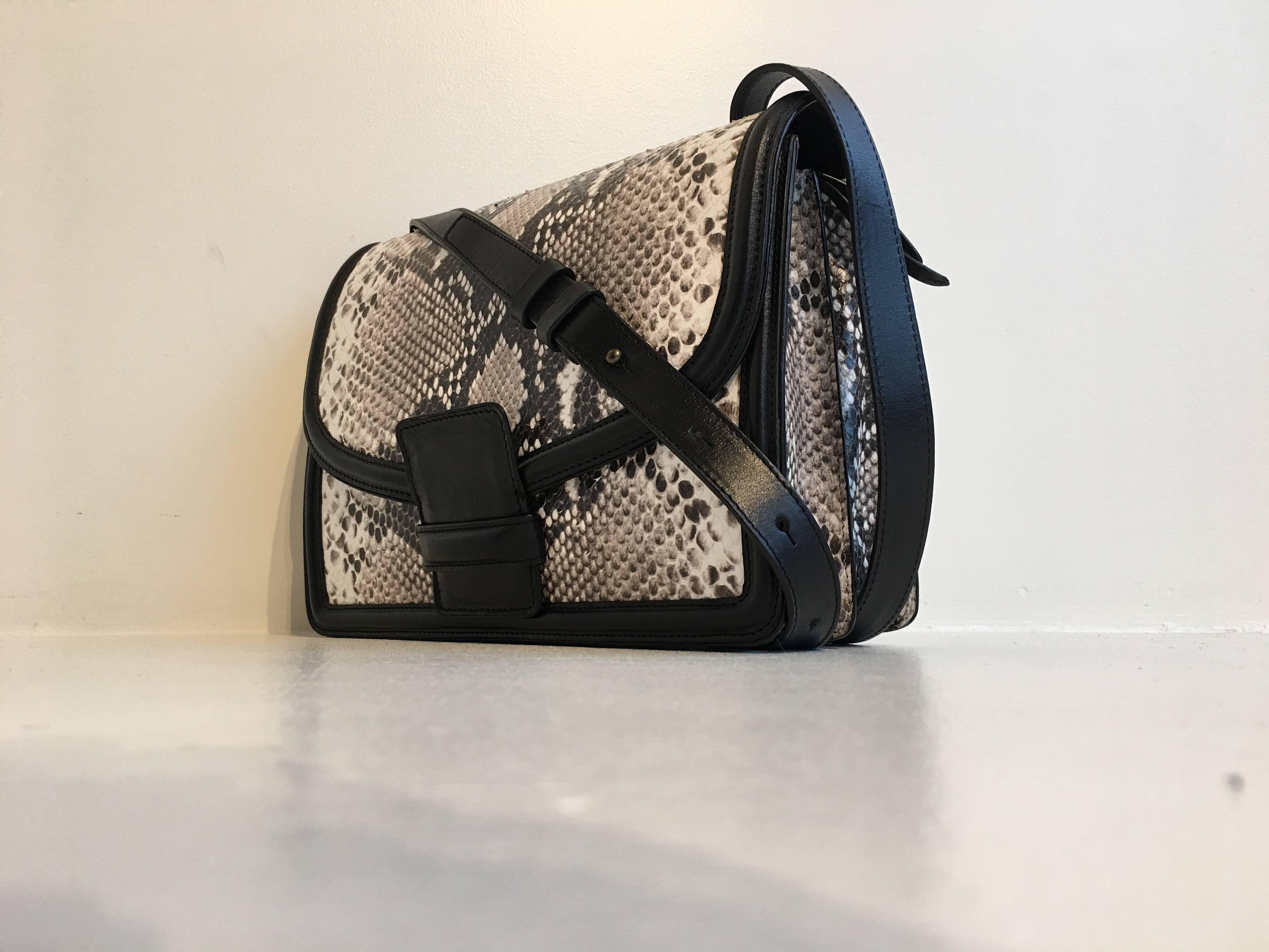 Dries Van Noten black leather and grey snakeskin effect finish purse from the AW16 collection, which was inspired by Marchesa Luisa Casati, an Italian heiress and patroness of the arts. It has a 43 inch long adjustable crossbody strap. The bag has