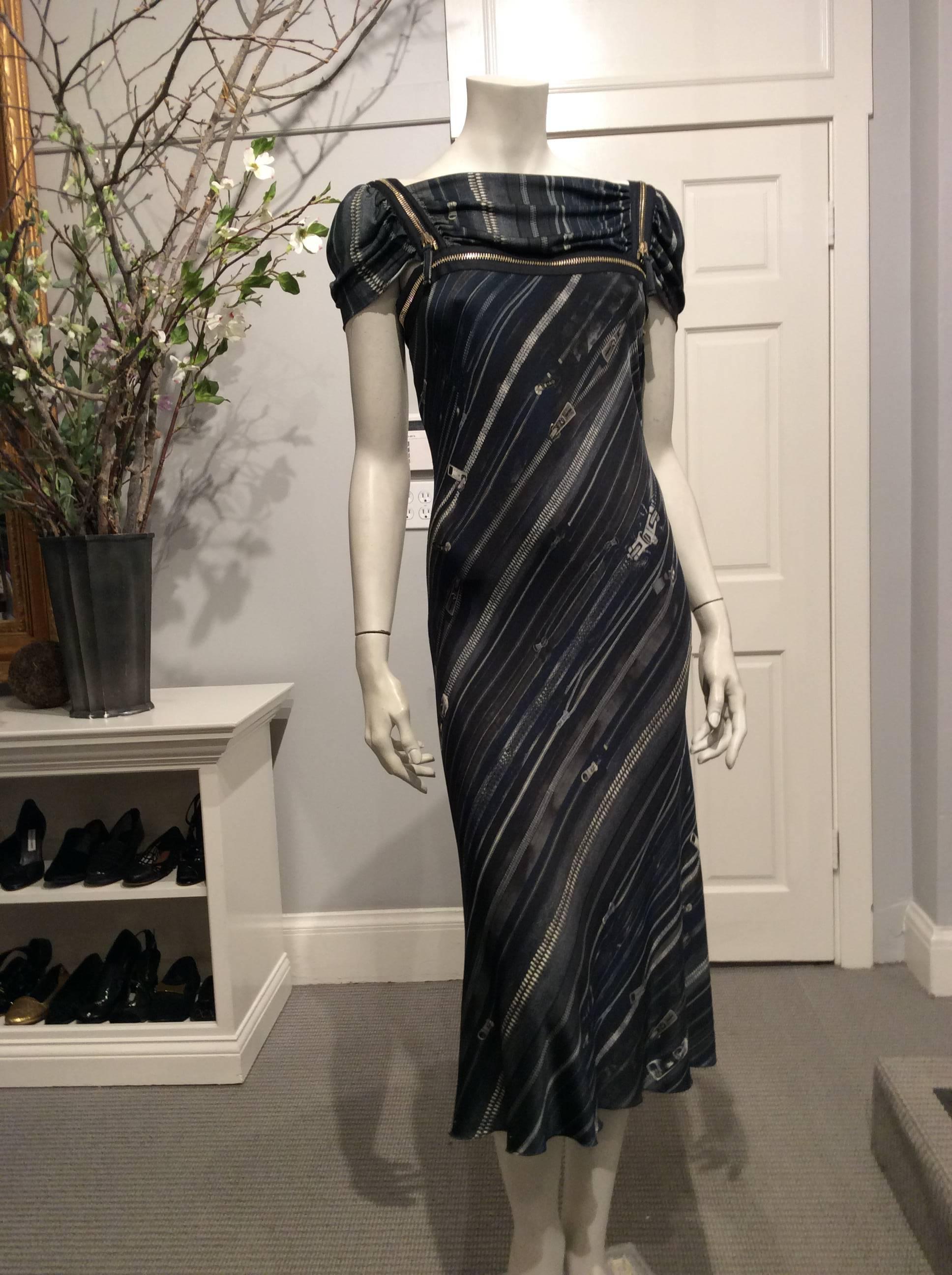 This Jean Paul Gaultier dress in grey, green, navy, and black is covered in an eyecatching trompe l'oeil zipper print. There are real working zippers on both shoulders as well as one above the bust and one in the back above the shoulder blades.  The