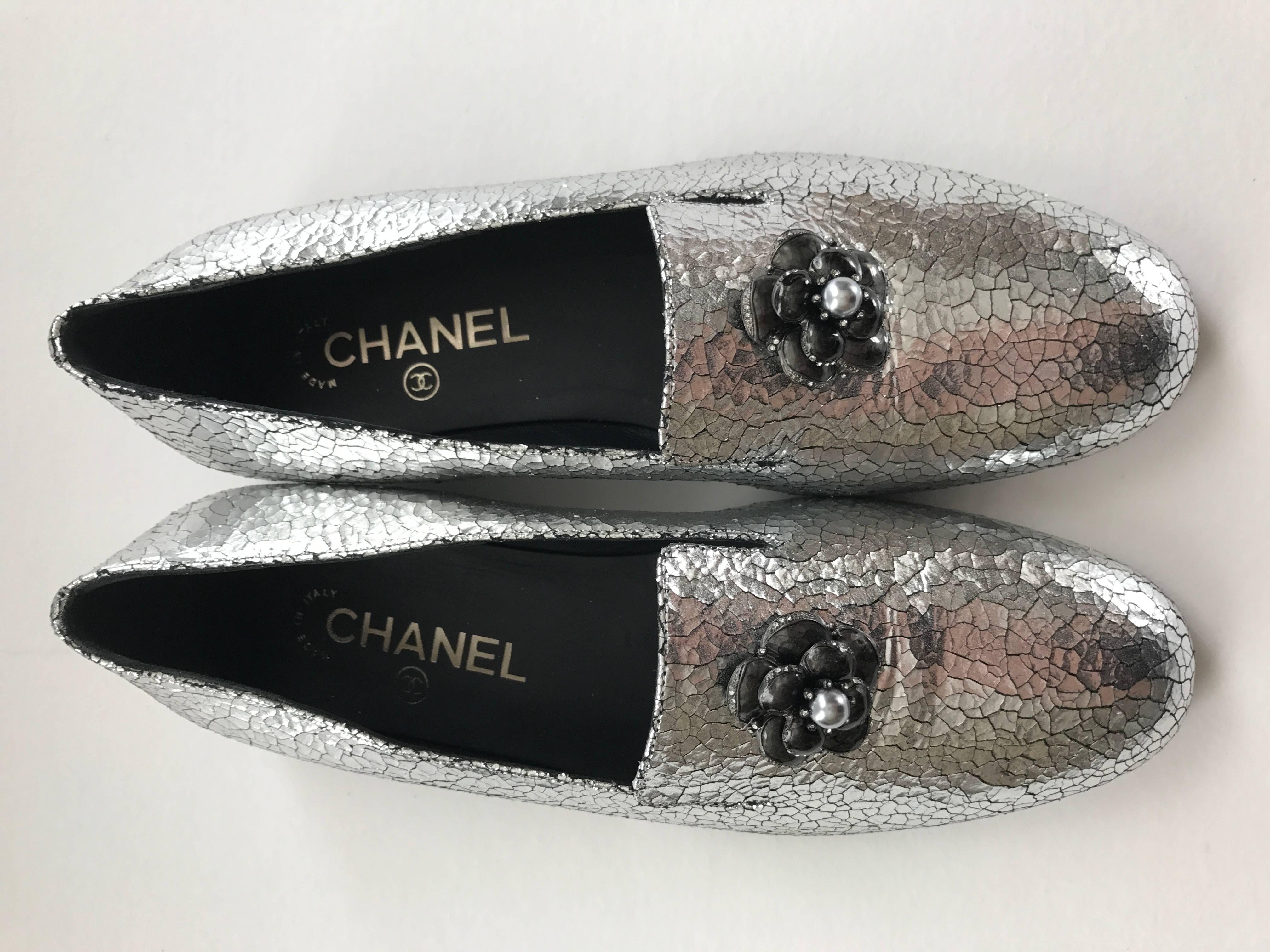 Eye-catching Chanel silver loafers in crackled leather with Gripoix pewter camellia embellishment. The flower has 
tiny rhinestone edging and a grey silver pearl in center. The marked size is 37 1/2 or US 7 1/2.
