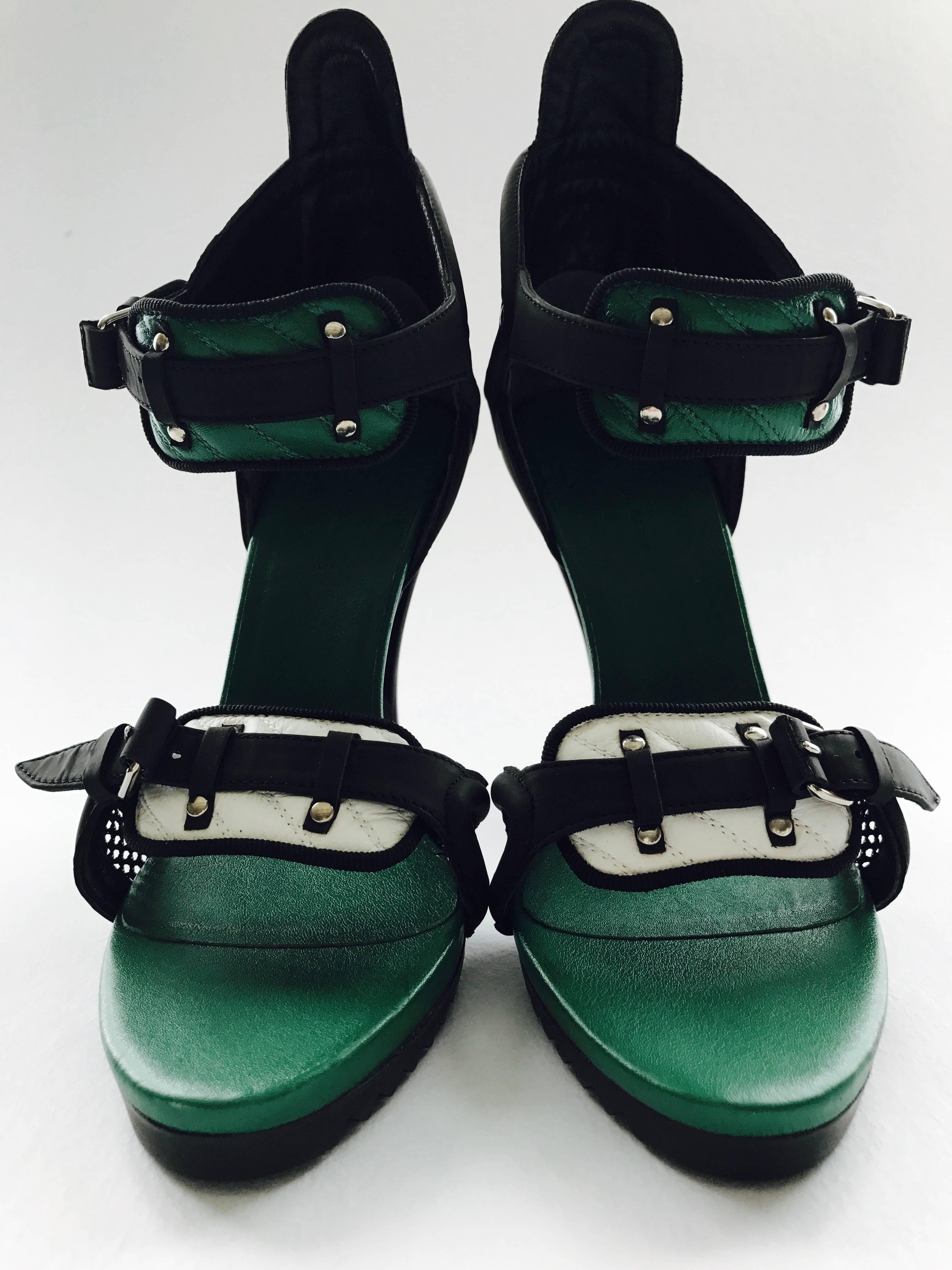 High heel black rubber ankle strap sandals with green quilted accent on the ankle strap and a white quilted accent on the toe part with black side netting. The shoe closes with two adjustable black straps that are 1/2in wide. The lower back of the