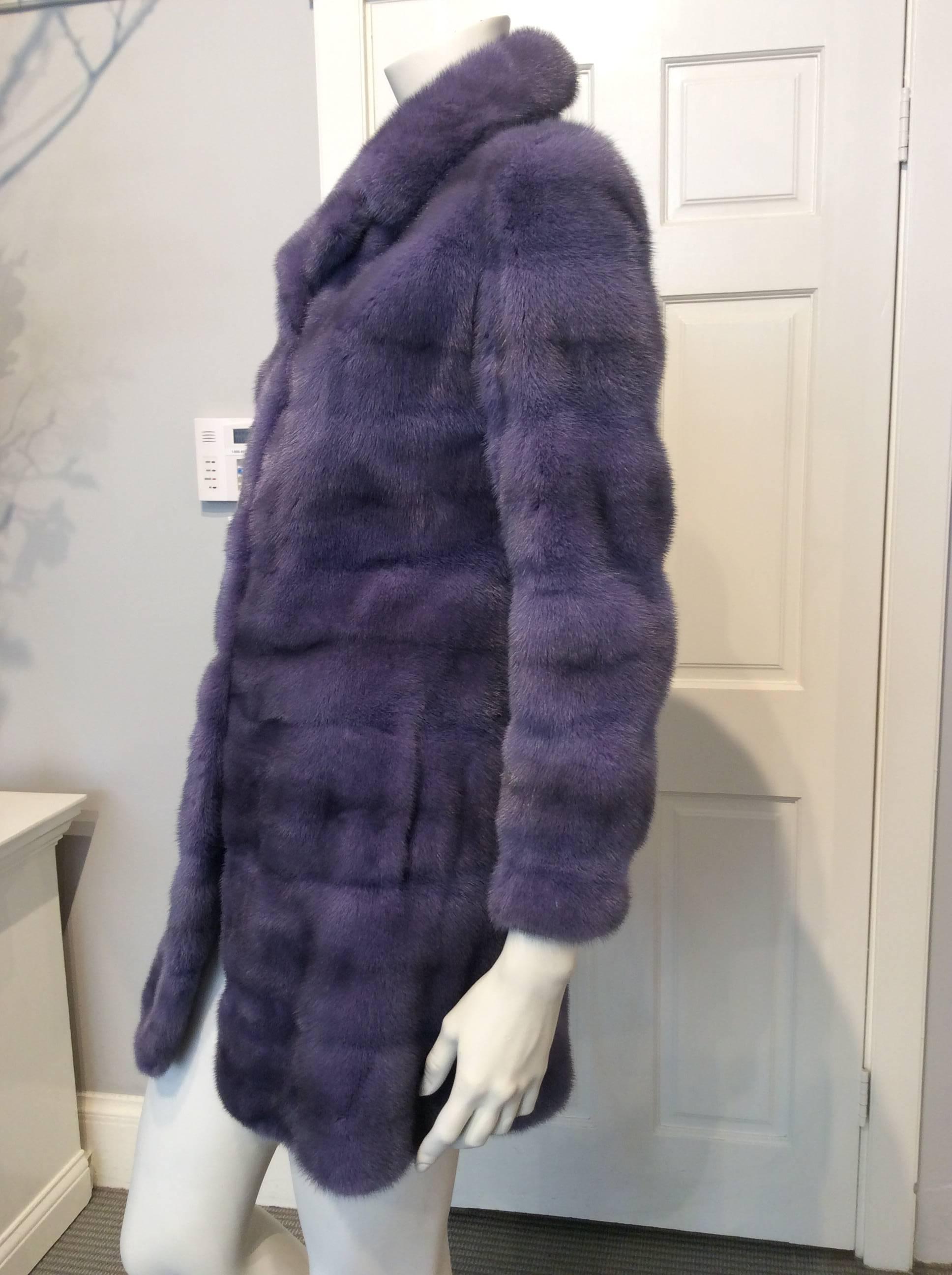 Show stopping Christian Dior 3/4 length mink coat in muted purple with dark grey shading By Saga Furs. It closes with three rectangular clasps are light gold brushed metal. It has two hidden front pockets. The lining is a very deep purple silk