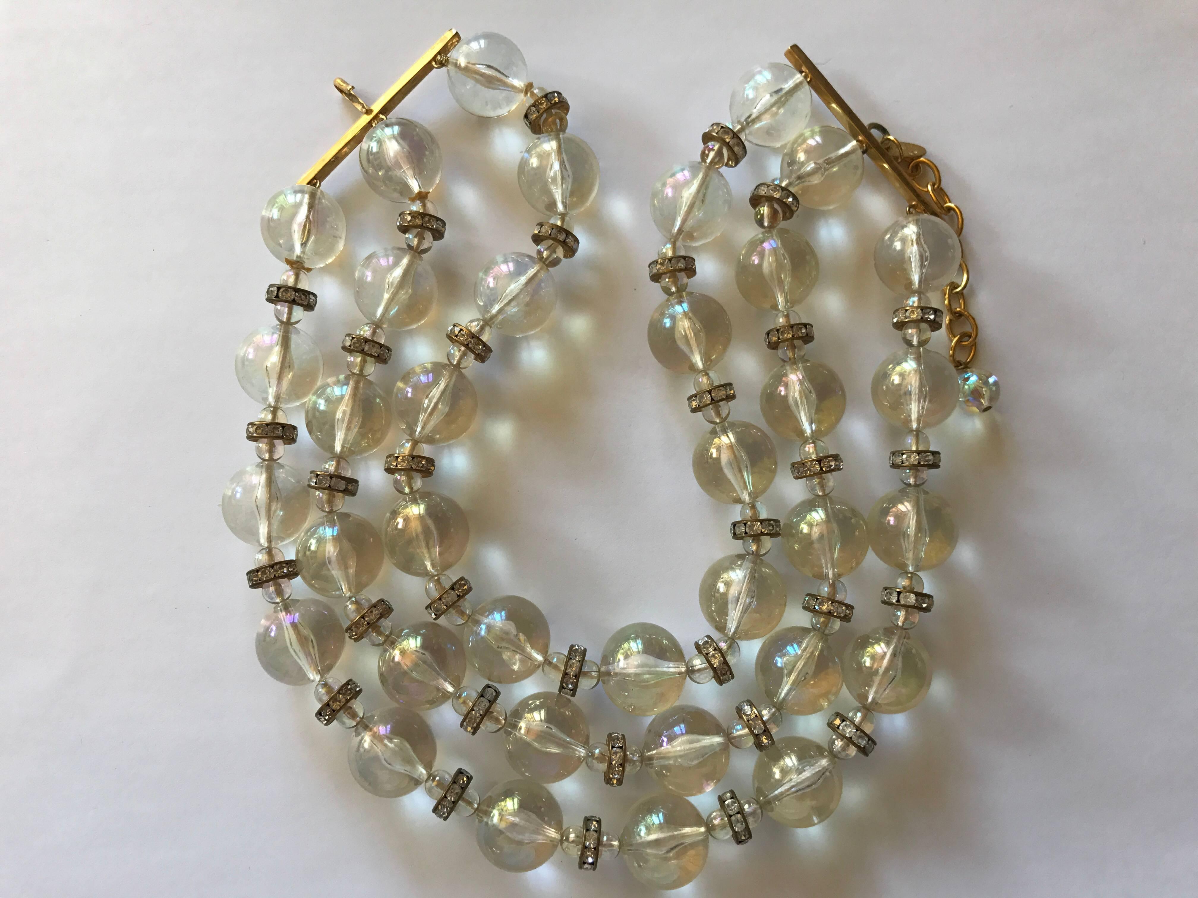 Chanel three strand acrylic beads necklace with gold hardware. The beads have an aurora borealis sheen and are interspersed with the same smaller beads and gold toned  rondelle beads with clear crystals. The height is 2 1/4 inches and the length of