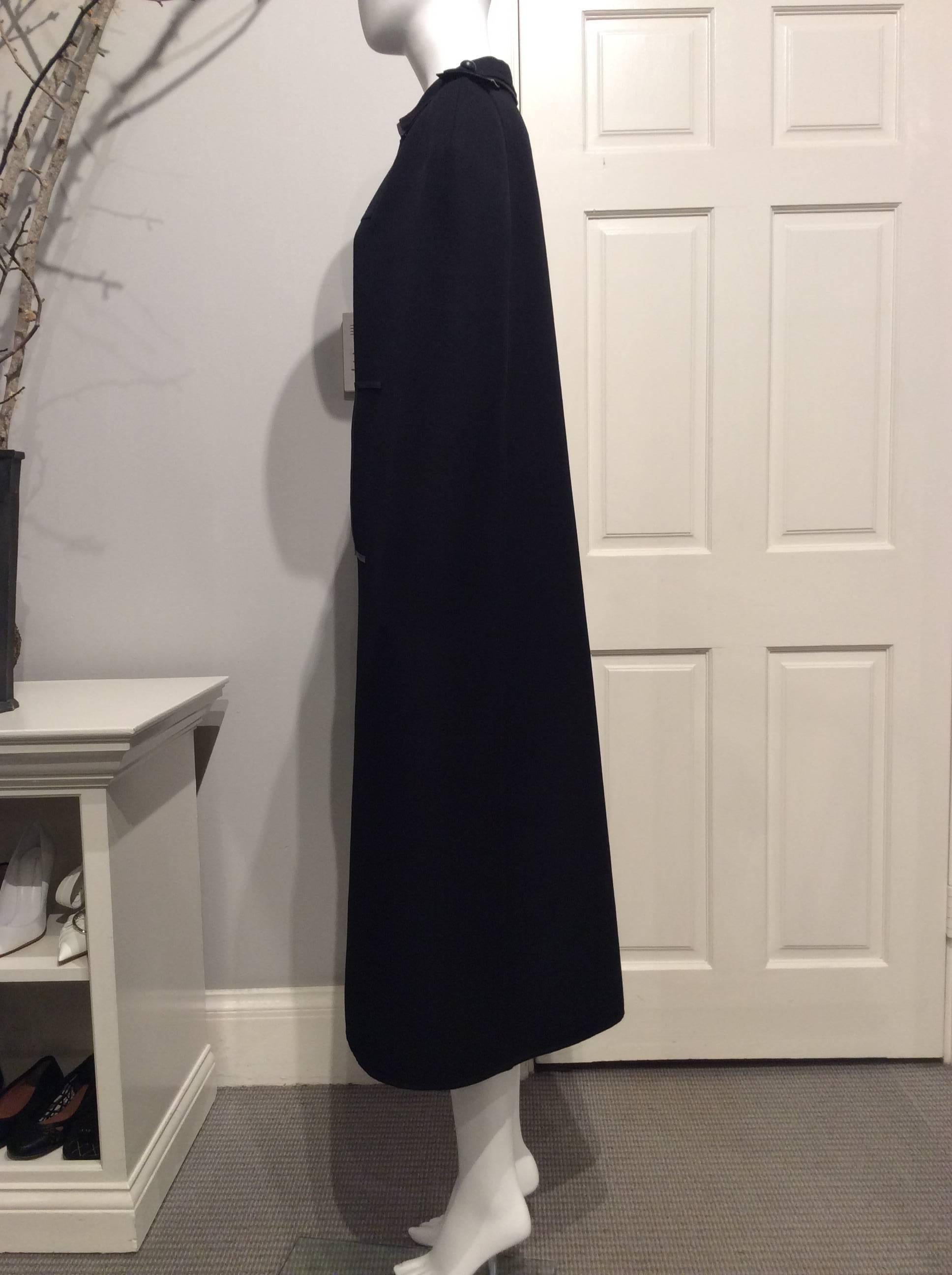 Long dramatic black Valentino wool cape with leather trimmed collar, mock pocket openings and epaulettes. The cape closes at the neck with two leather covered buttons on a silver chain. The item is brand new with tags showing the original price of