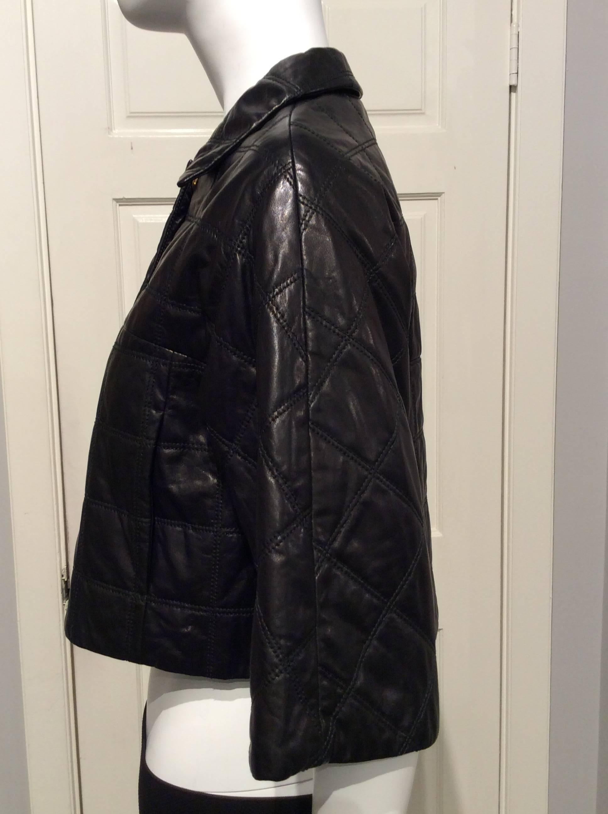 Prada black light weight, waist length leather jacket with a double stich quilted pattern. It has elbow length sleeves, two 5.5in  slit pockets, it closes with five gold toned snap buttons and an additional gold toned zipper. 