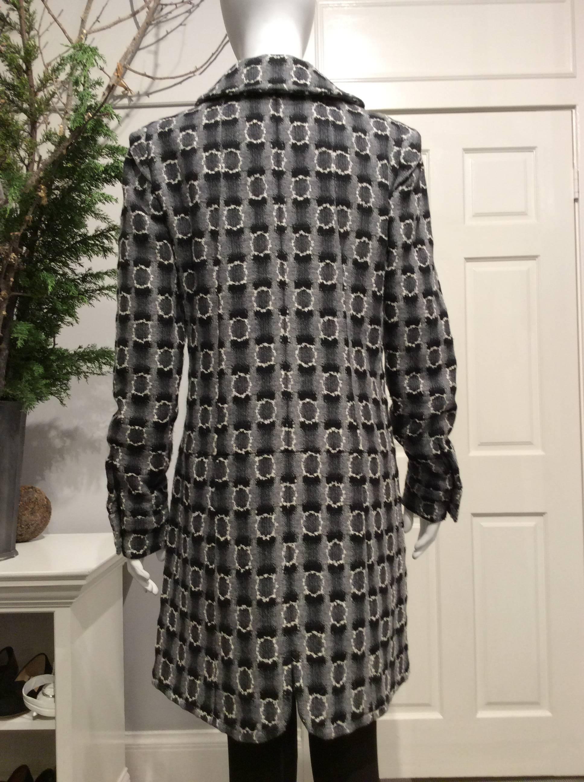 Chanel coat with small round collar and a mock one that tapers to the back into the sleeve seam. It closes with a pewter colored zipper. It has two 11in x 8in vent top pockets with a flap that’s held down with two pewter iconic CC buttons. The