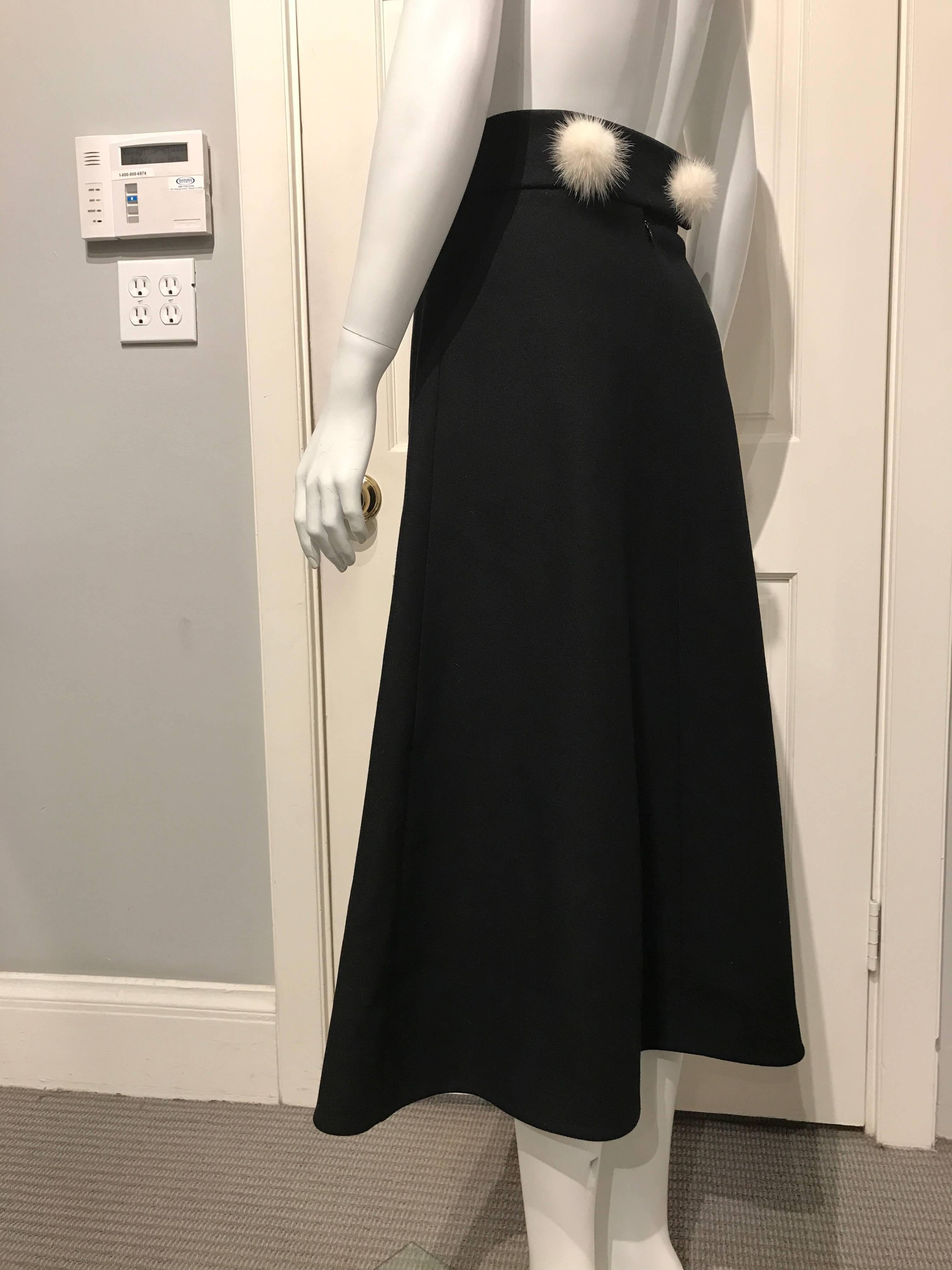 Louis Vuitton black A-line long wool skirt . The waist band is 2.5in high and is highlighted with two white Mink pompons in the back one on each side of the zipper.

This piece matches the black Louis Vuitton jacket with white Mink pompons featured