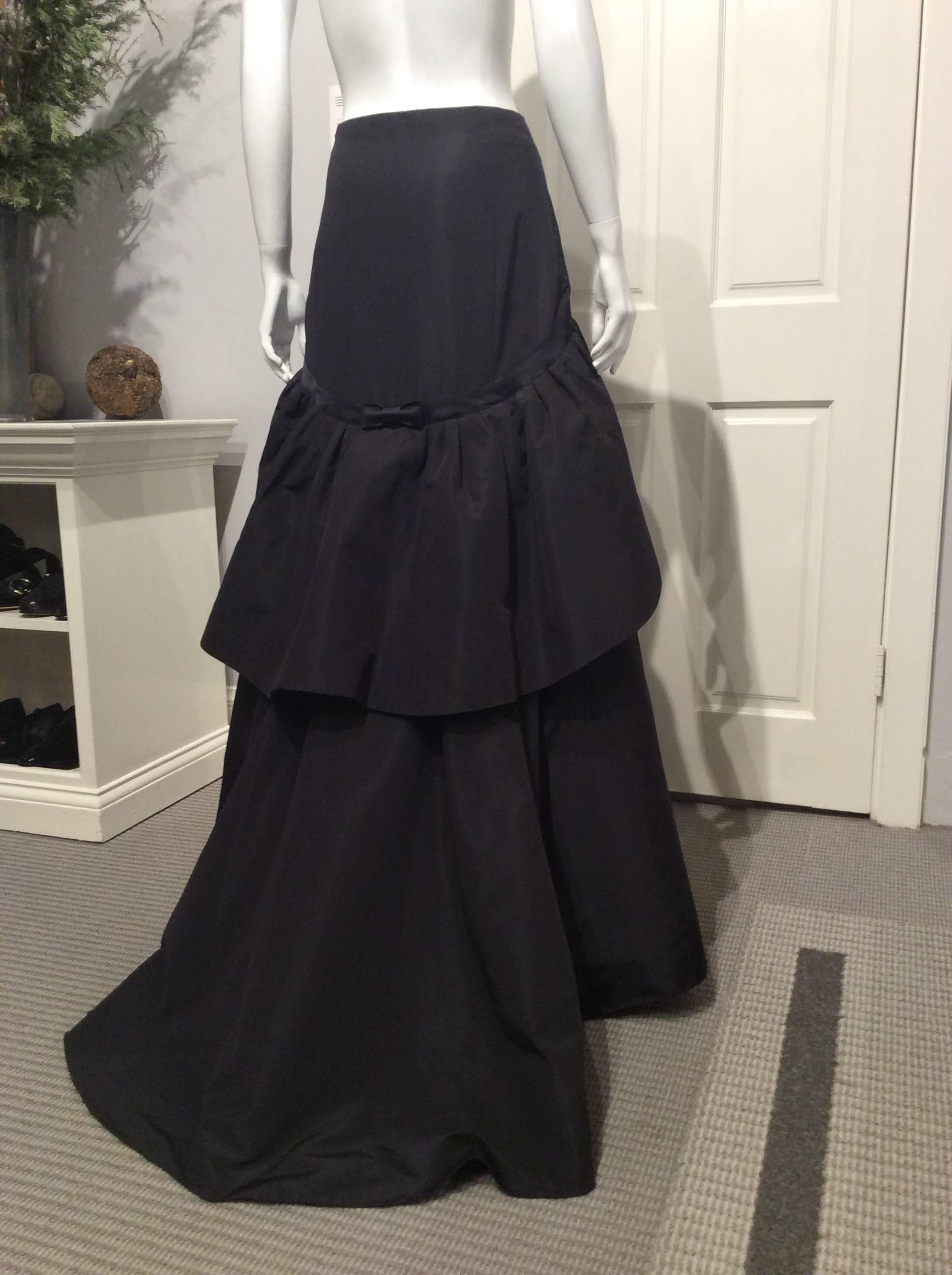 Rochas multilayered long taffeta skirt with a slight train. It has inside shorter layers and whalebone trim to give the skirt extra fullness. A 1in satin trim with a flat bow in the back separates the fitted part from the full part.