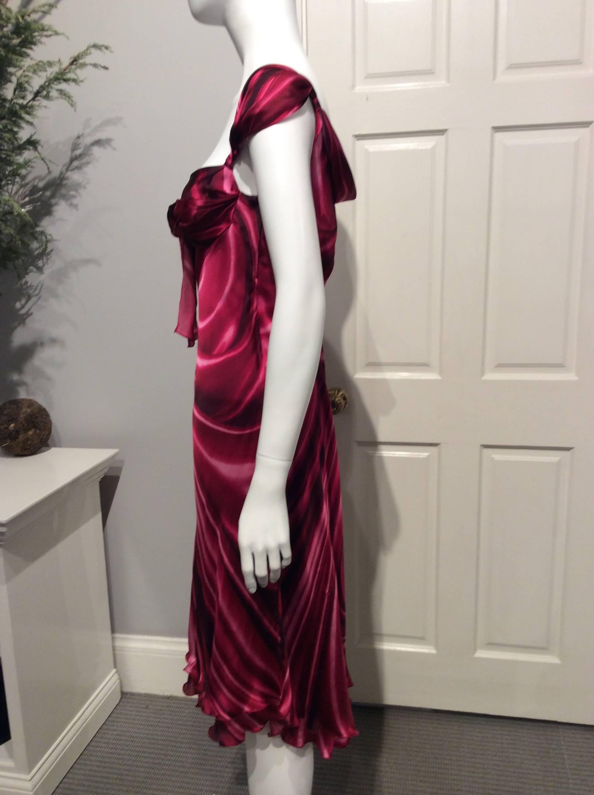 Moschino bias-cut silk satin dress in different shades of magenta to deep burgundy in a faux drape print. The skirt is double layered with the lower being 2in longer. The skirt  is cut slightly (5in) longer in the back. The garment has 4in hidden