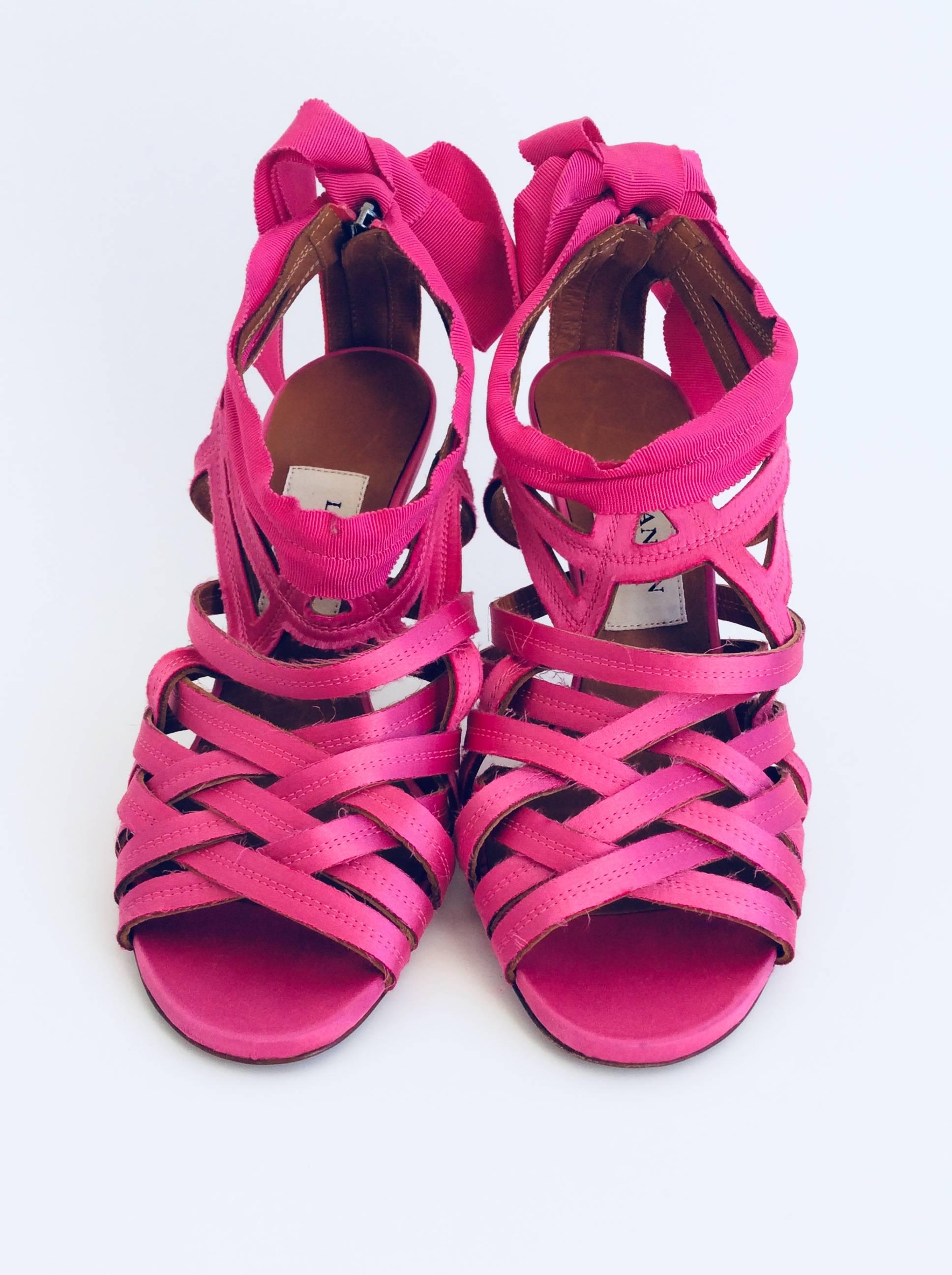 Lanvin candy pink sandals made with unfinished strips of satin a  gros grain ribbon that closes in a bow at the ankle. The height of the pewter metallic heel is 4in and they have a zipper in the back of 2 3/4in. 

Please note the shoes are sold as