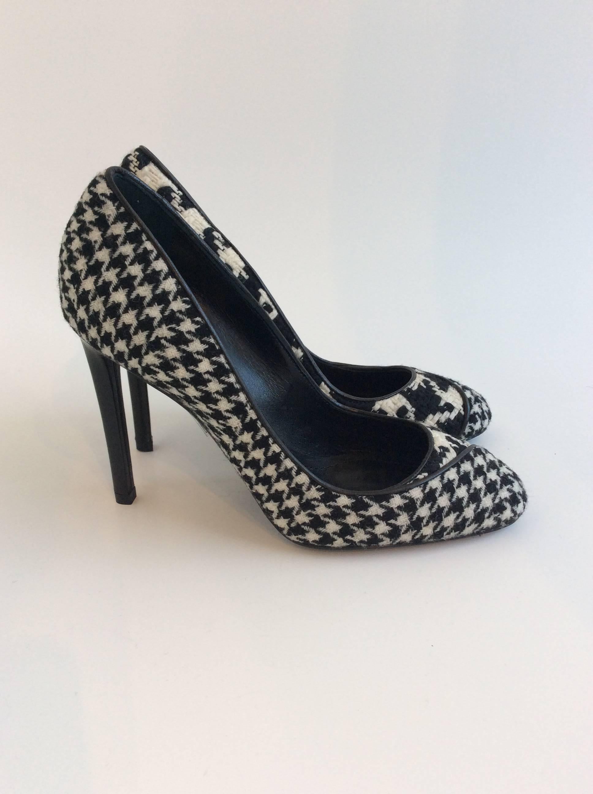 Black and cream wool fabric Christian Dior pumps in two different houndstooth patterns trimmed with black leather. The 4in heels are covered in black leather.


