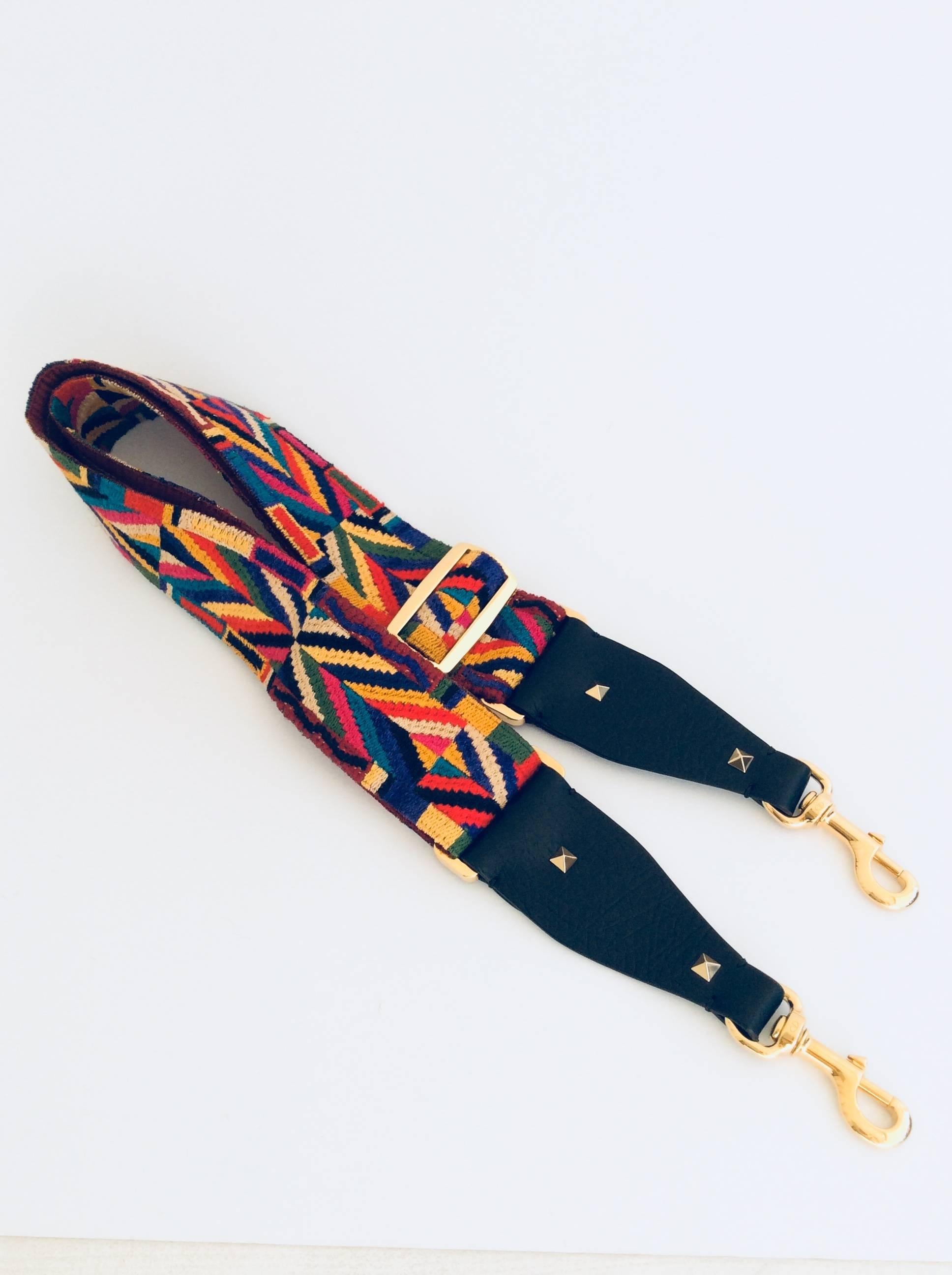 Valentino colorful southwestern inspired adjustable cotton shoulder strap embroidered in Native Couture 1975.
The buckles are gold colored metal as are the two lobster clasps on the black Stampa Alec leather ends.

Dimensions: 54” L - 2” W
