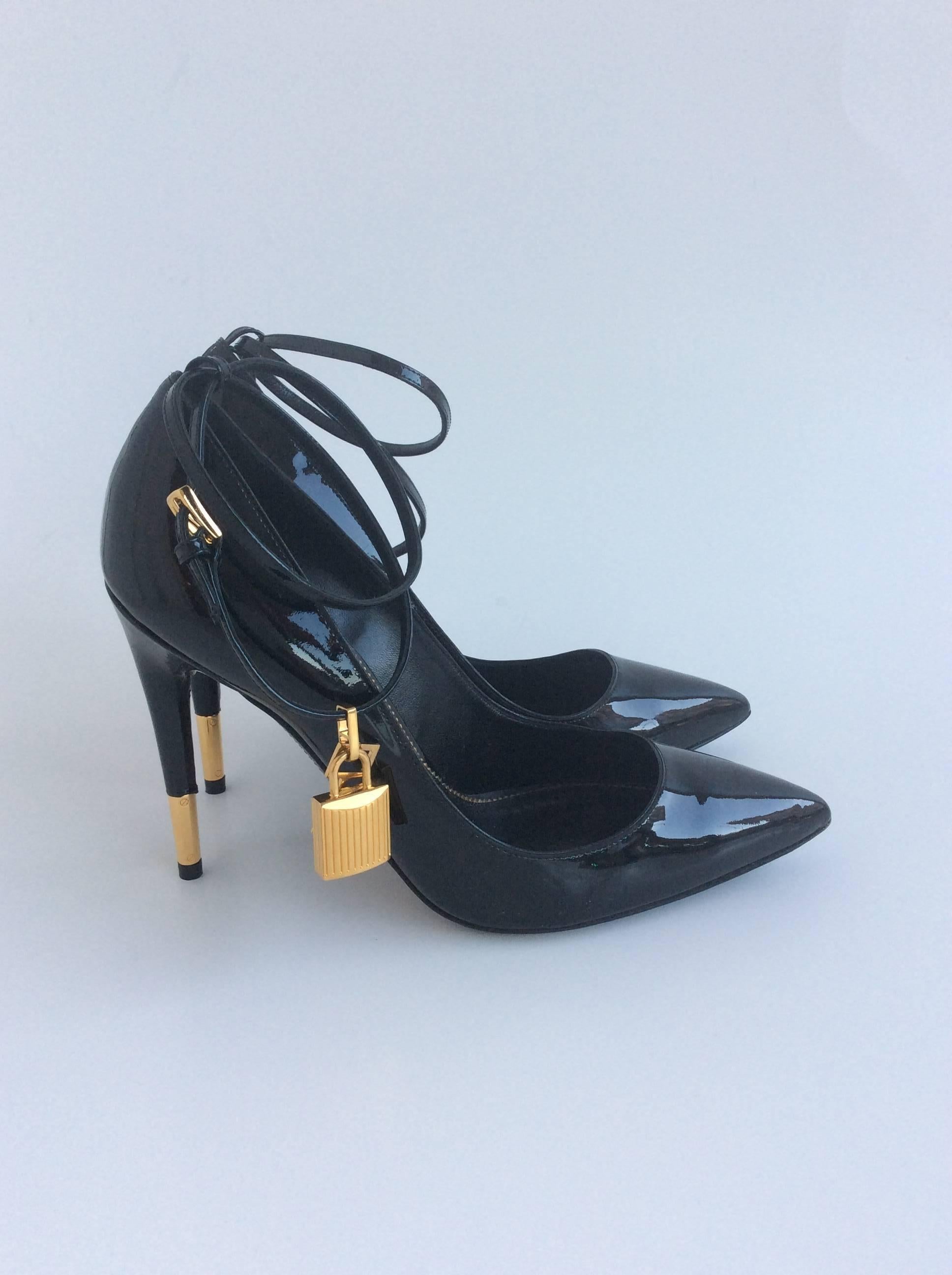 Striking Tom Ford black patent pointy pumps with double ankle strap with a gold lock and key removable charm on each shoe. The gold tipped stiletto heel is 4”.

The shoe are brand new bu the soles have been purposely scratched to avoid slipping.