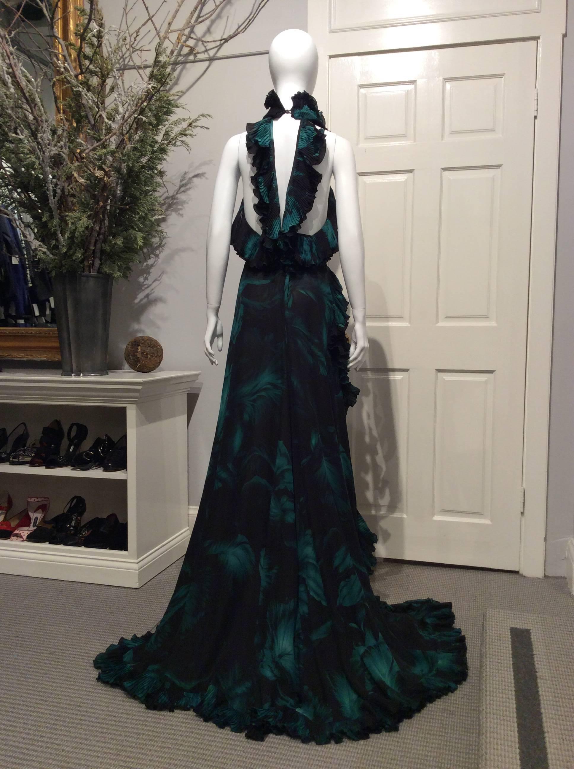 Long Gucci silk satin gown in a black and deep green tropical leaf print with a low back.  Pleated ruffles are strategically placed to enhance the neck, back straps, and edge.  The hip high slit of the flowy skirt pools on the front and has a slight