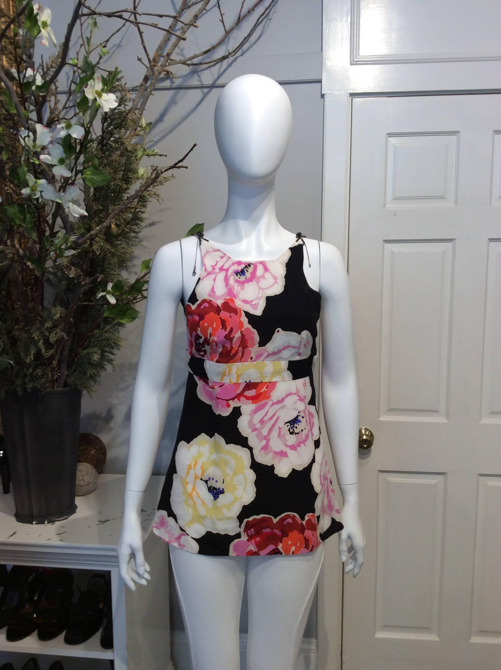 Chanel black silk top with yellow, pink, red, and white camellias printed throughout. Zippered closure with single black spiked enameled button at back. Two gunmetal and black enameled 