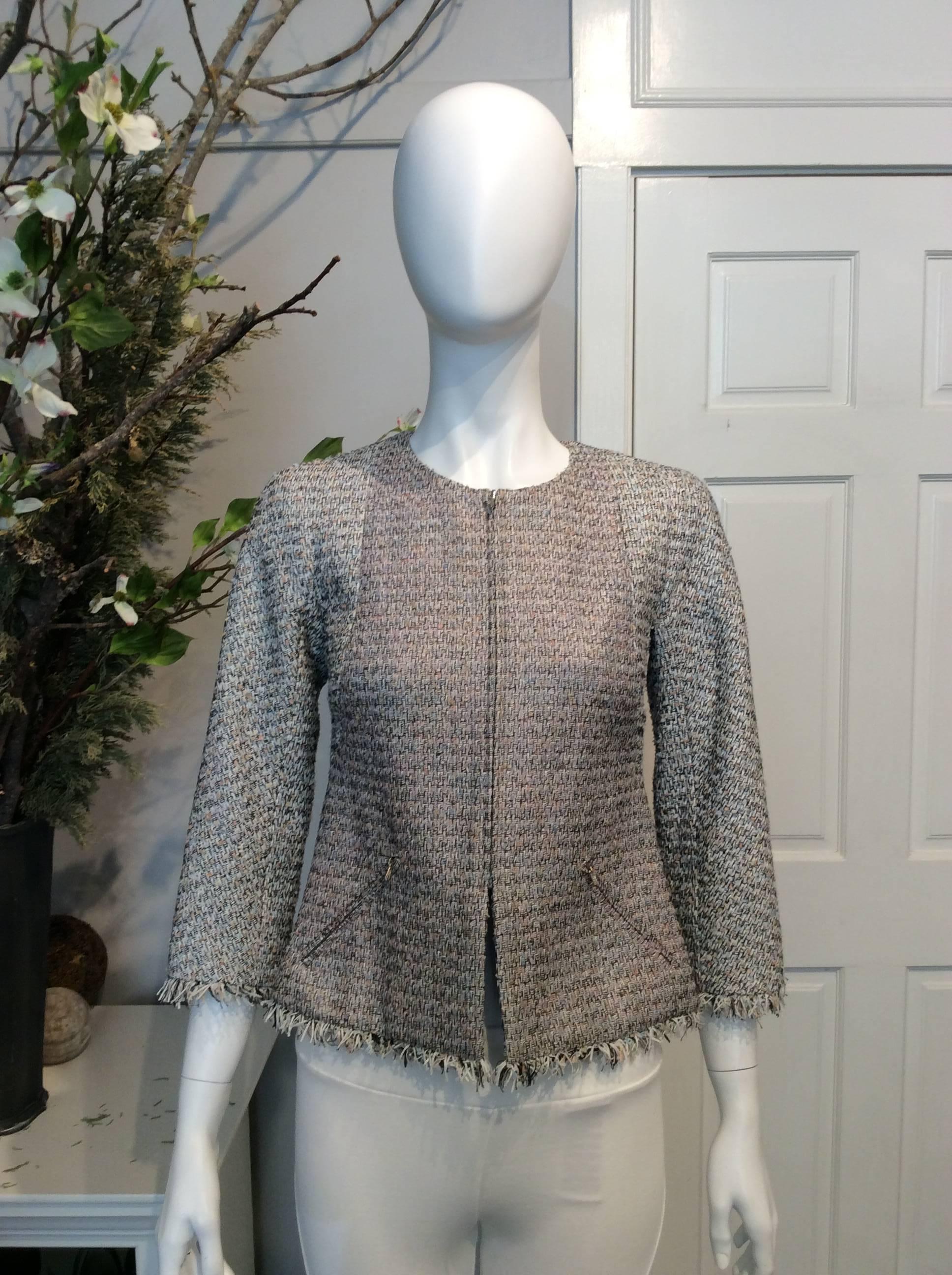 Chanel gray, white, black, light pink, light blue, and coral tweed jacket. Fringe on sleeves and at bottom of jacket. Jewel collar. Dual pockets with silver zippers. Silver zippered closure at front. Four buttons at rear sides of jacket with silver