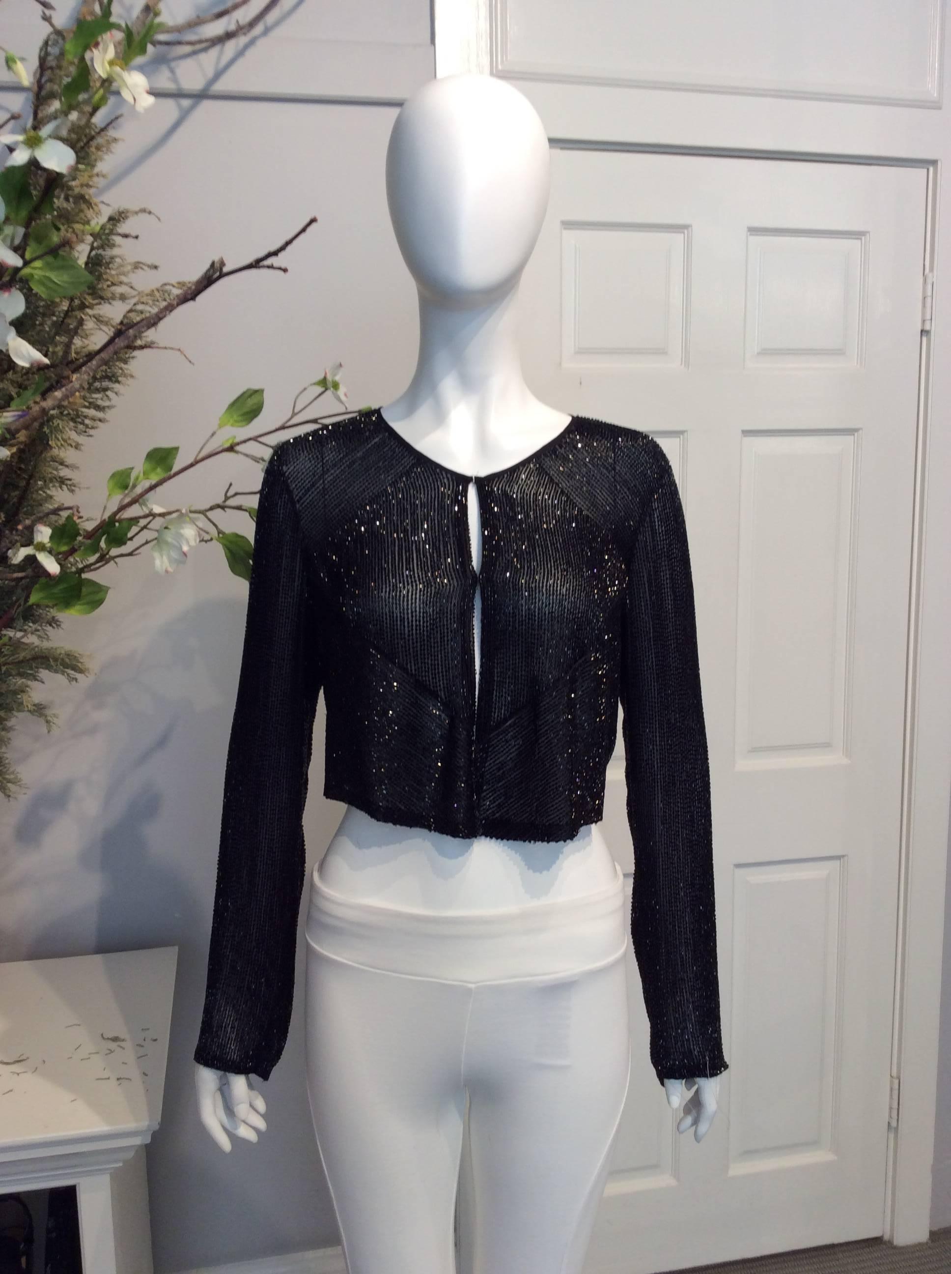 Chloe black beaded silk cropped evening jacket. Jewel neckline. Triangular beaded pattern at chest. Beading throughout entire piece.

Sizing: Fr36, Us4

Fabric content: 100% Silk