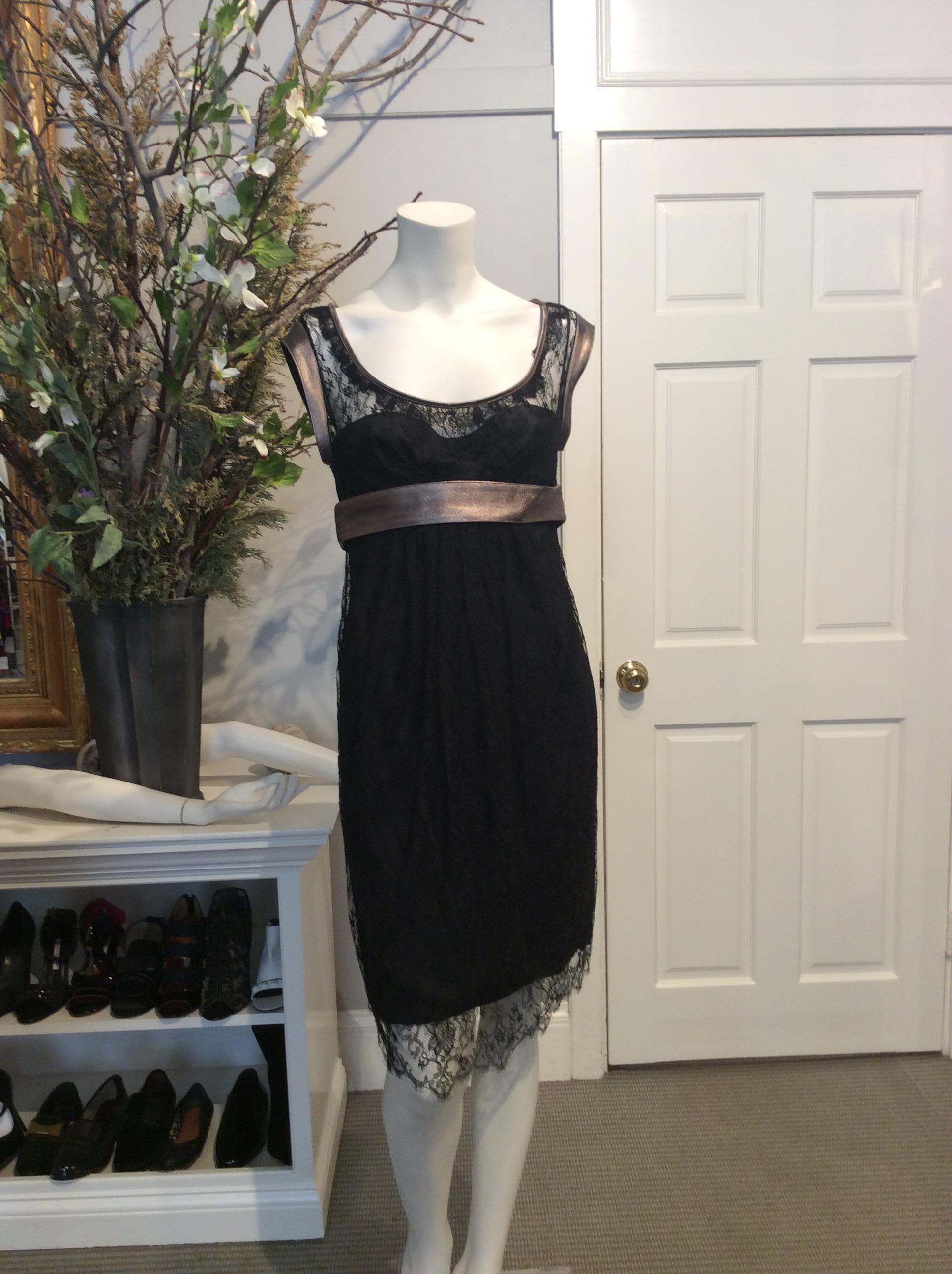 Black lace Dolce and Gabbana dress. Black silk slip dress/lining attached under lace. Gunmetal lambskin trim on neck and shoulders. Wide gunmetal lambskin belt at waist with two snap closures. Zipper located at back of dress with single hook and eye