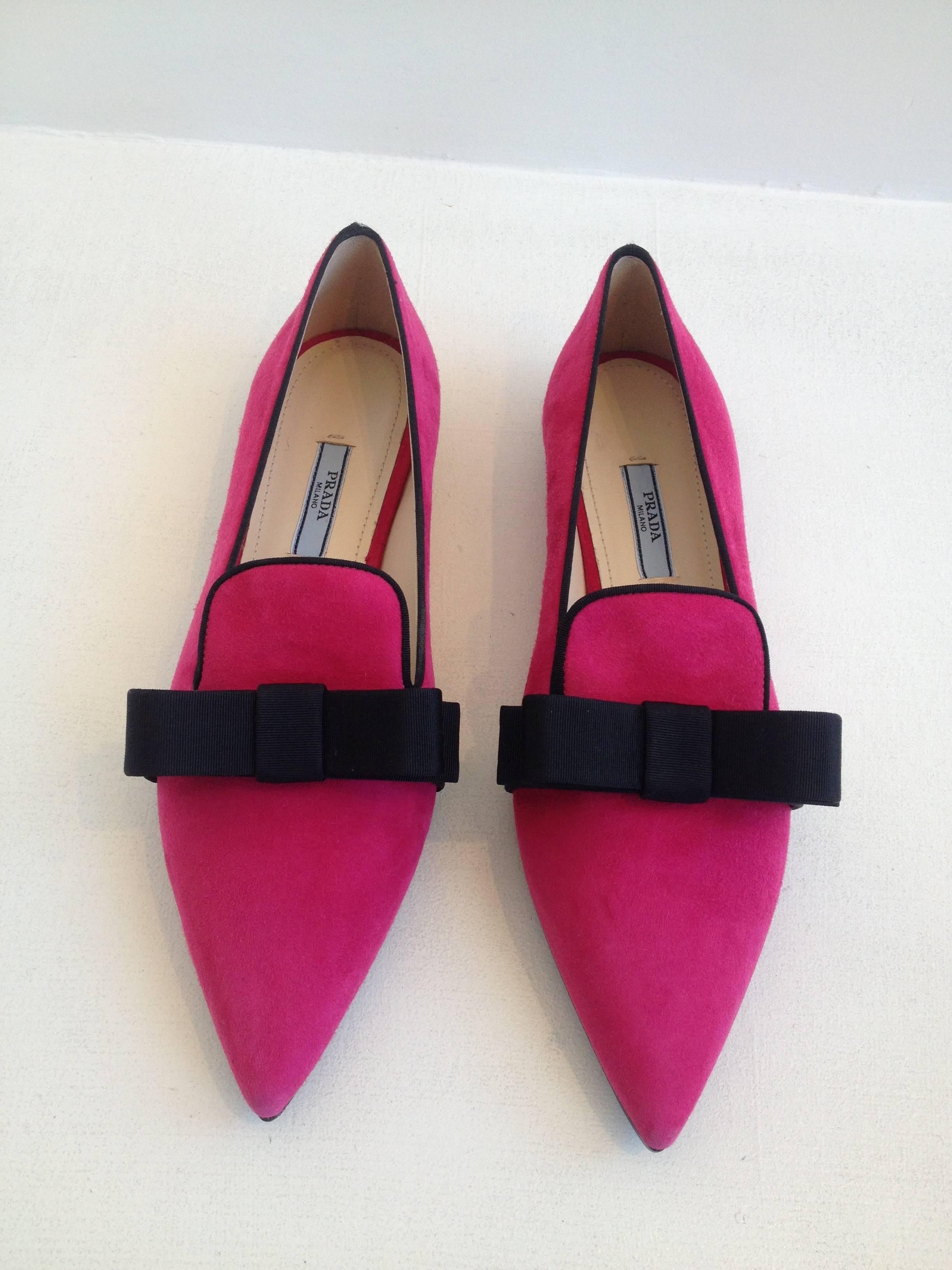 Nothing adds quite so much fun to your look as a pair of pink suede skimmers. These are trimmed with oversized black grosgrain bows on each pointy toe, adding the perfect contrast to the pink. Wear with anything from a party dress to black pants and