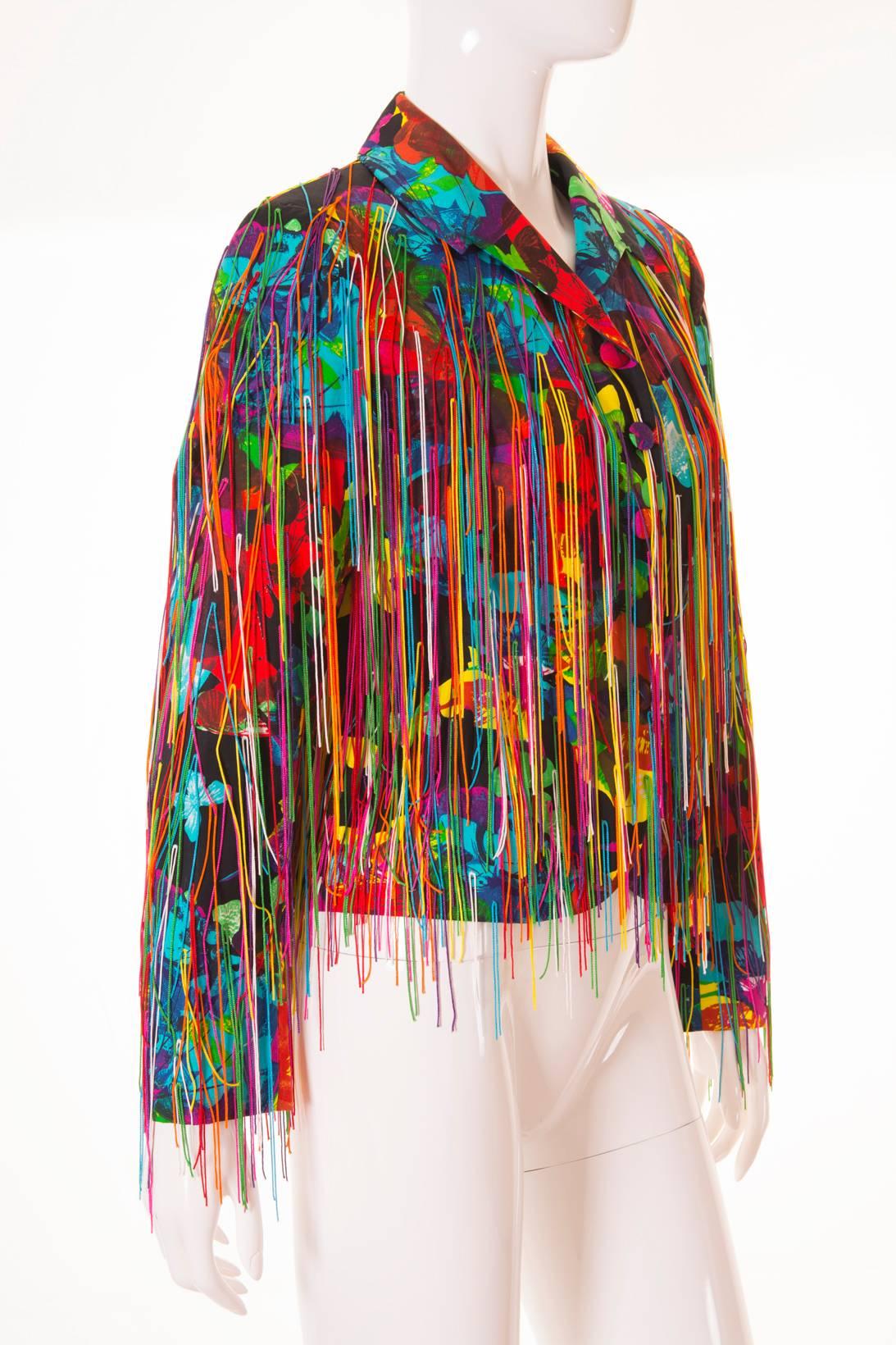 This jacket by Moschino Couture is absolutely breathtaking.  The piece, designed by Franco Moschino, features a vibrant rainbow floral all over print and is covered in multicoloured fringing.  We love the way this garment moves when worn.  Single
