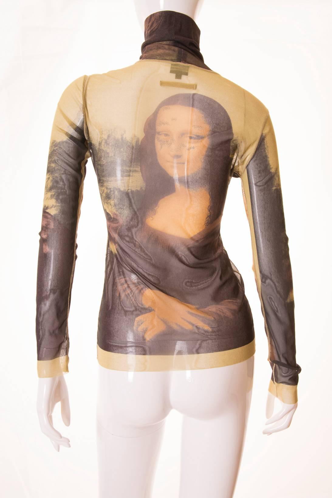You don't need to go to the Louvre to see a masterpiece. This sheer turtleneck top by Jean Paul Gaultier features Leonardo Da Vinci's masterpiece, the Mona Lisa printed on the front, back and sleeves. Deconstructed style. The top has a raw hem at