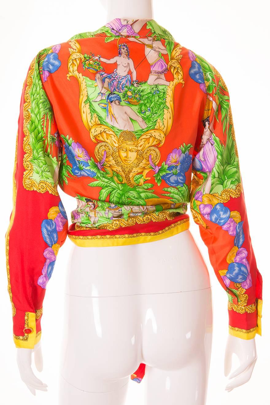 This Gianni Versace Couture blouse has a super low cut and ties at the front. Lush, detailed Indian themed print.  Baroque flourishes on the arms of the jacket.  Rich and vibrant colours. Red signature Versace Medusa's head buttons on the cuffs.