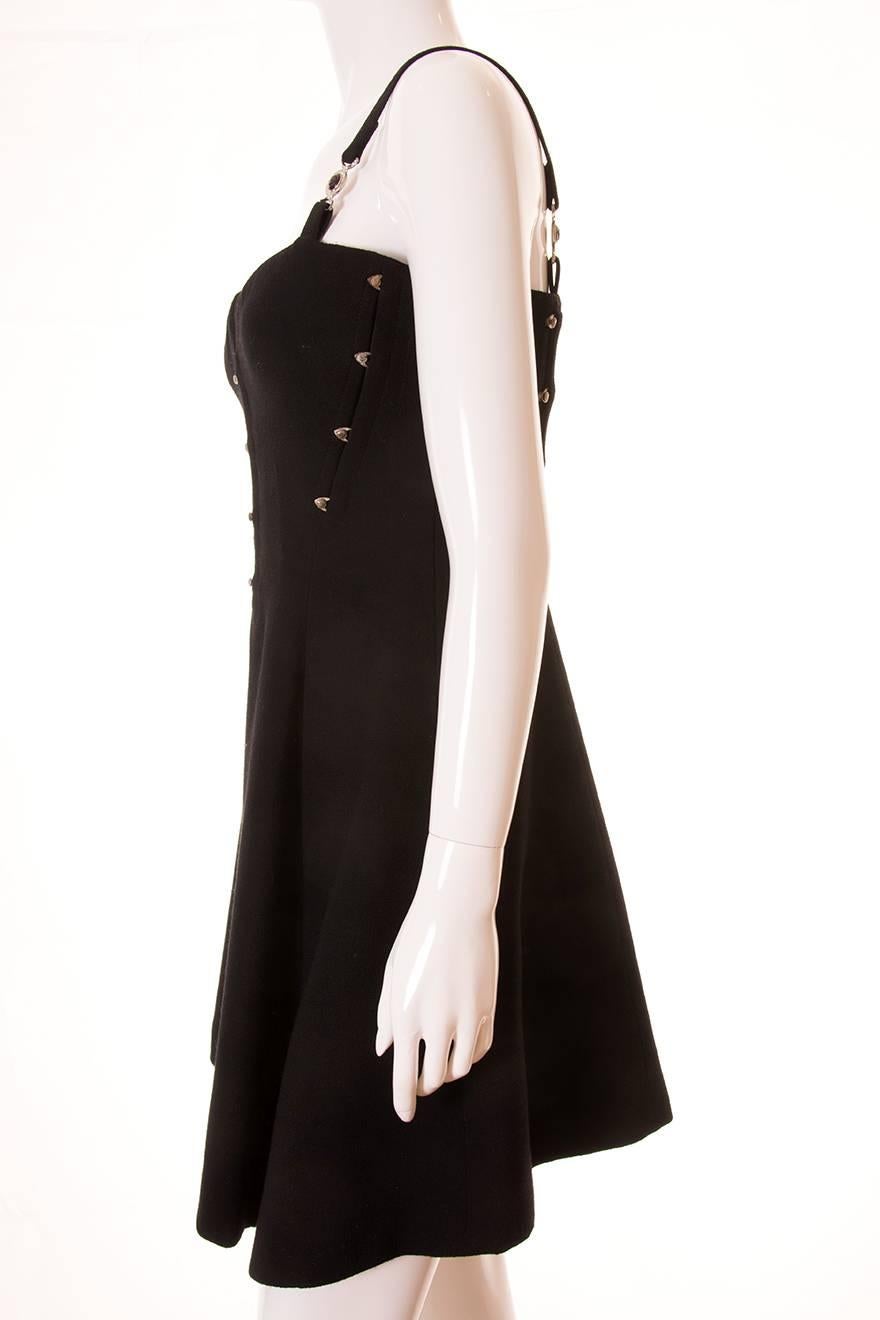 A stunning little black dress by Gianni Versace.  This dress has a boned, corset style bodice with tiny signature Medusa's head buttons on hooks.  The straps also feature the Medusa emblem at the front and the back.  Asymmetrical hem.  Flattering