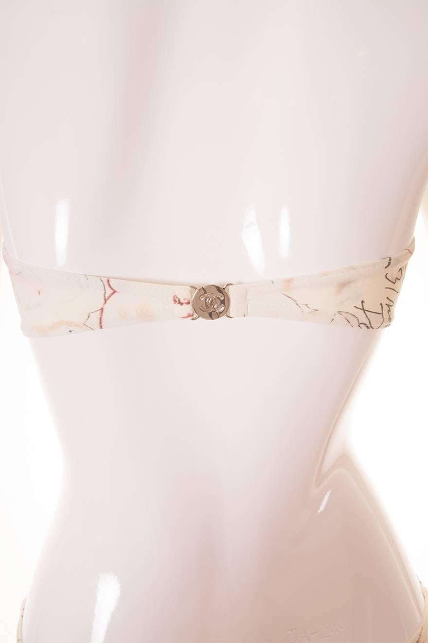 This rare Chanel bikini from Spring/Summer 1998 has a bandeau style top and high waisted bottoms.  Unlike other vintage bikinis, the cut is extremely current and on trend.  It features a sketch and watercolour style print in cream, grey and pink,