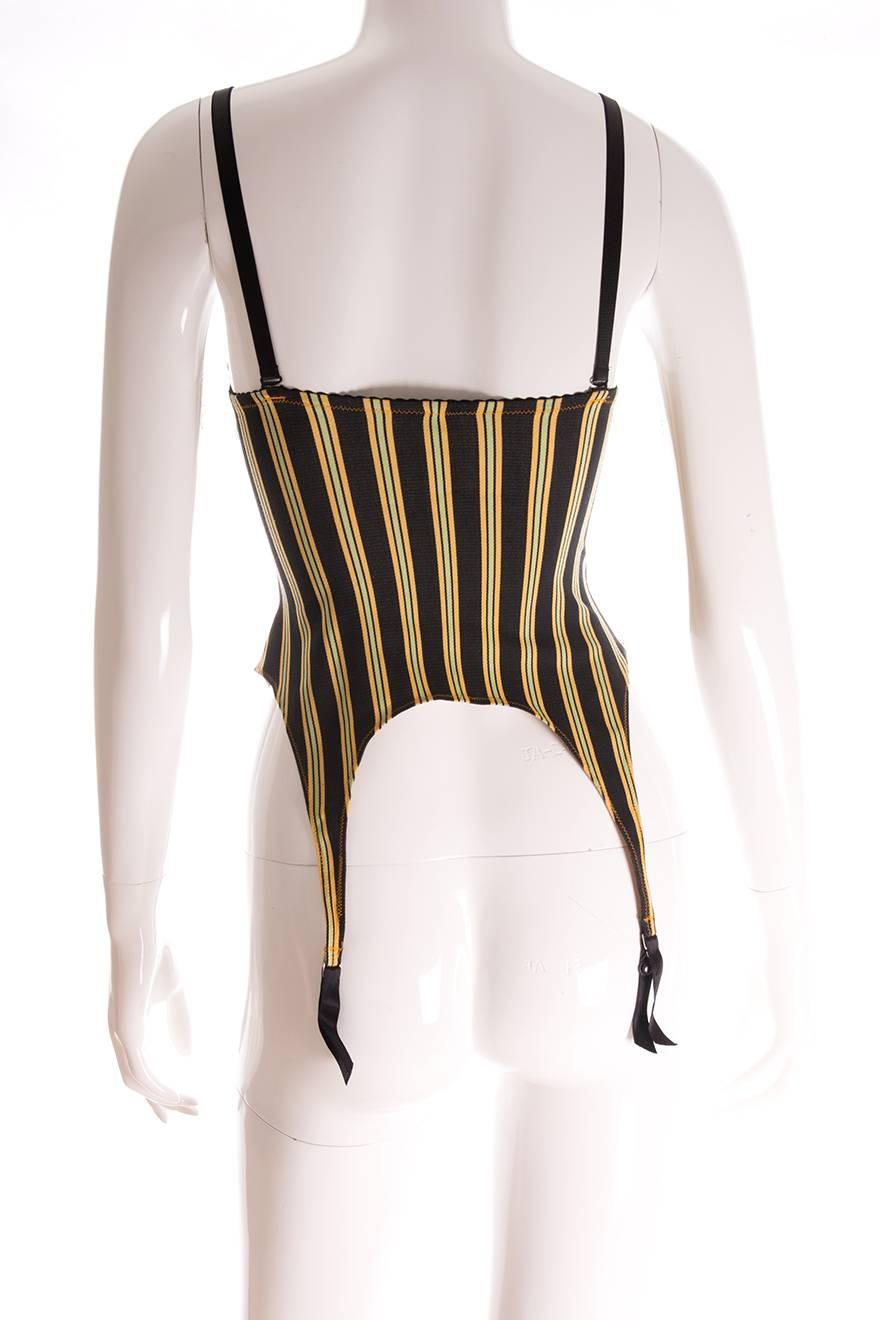 So “Blond Ambition”.  This bustier top by Jean Paul Gaultier has hanging garters at the bottom as well as adjustable straps.  Black offset with contrasting green and yellow stripes. Articulated bust cups.  Circa early 90s.

Marked size - M
Waist