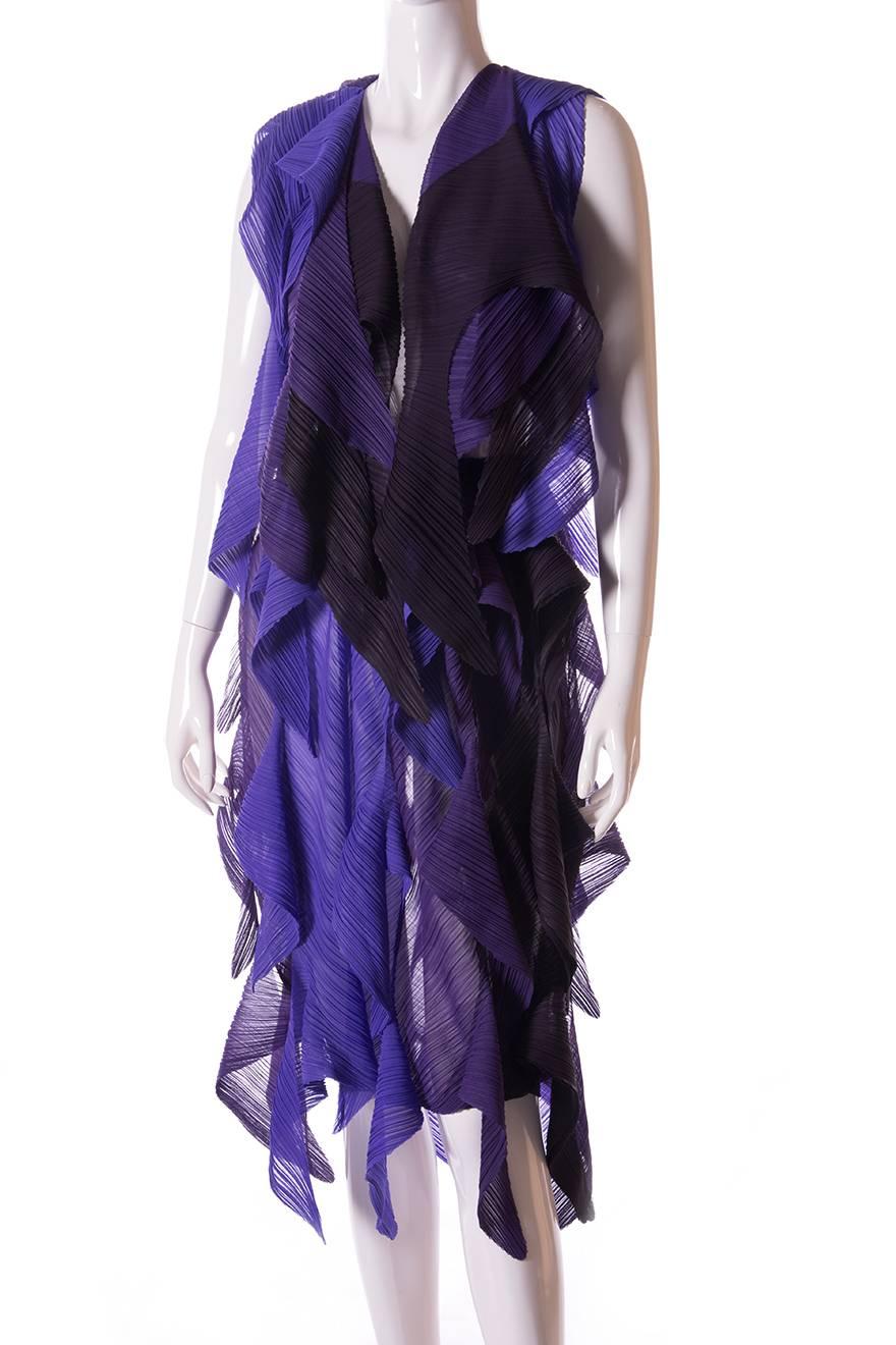 This is an incredible top and skirt set by Issey Miyake Fete, which is made of slightly sheer panels of pleated fabric in black and shades of purple.  This set drapes beautifully when worn on the body.  The top is an open vest, which is paired with