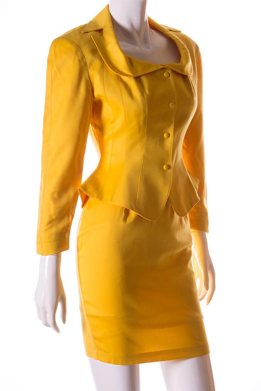 This two piece suit by Thierry Mugler in a bold shade of canary yellow will be sure to get you noticed.  The jacket nips in at the waist and flares out, giving that exaggerated wasp waist look Mugler was renowned for.  Shoulder pads and darts along