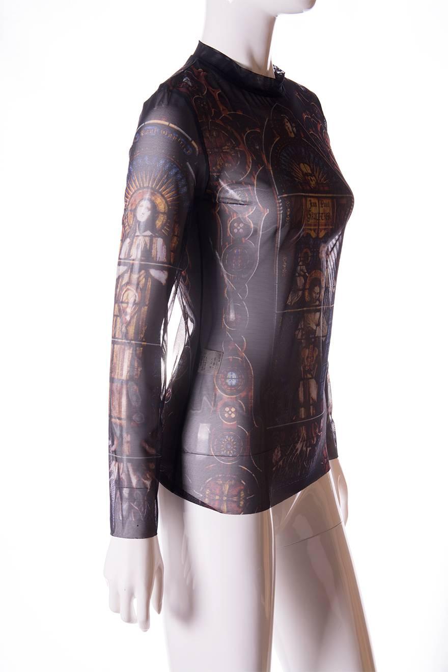 Sheer long sleeved top by Jean Paul Gaultier in a stained glass religious art print.  High neck.  Raw edged hem at the bottom of the shirt and sleeves.  Circa 90s. 

Marked size - 40
To fit - S

Chest – 40 cm
Length – 63 cm
Sleeve – 75 cm