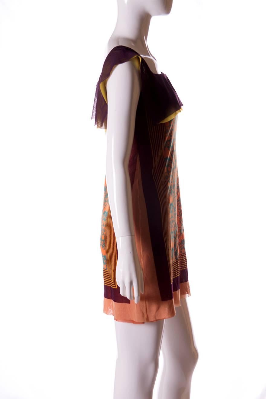 Boat necked dress by Jean Paul Gaultier in a tribal and geometric print.  The fabric itself is sheer but there is more than one layer so the effect is only slightly sheer when worn.  Mini length. Circa 90s.  

This dress is in excellent condition