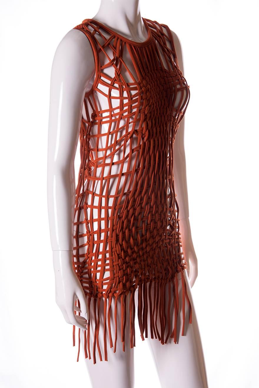 Macrame dress in rusty orange by Jean Paul Gaultier.  Ultra short length and fringed hem.  This piece can also be worn as a top.  Pair it with a nude slip or go bold and wear it with a black bra and underwear poking through underneath for a more