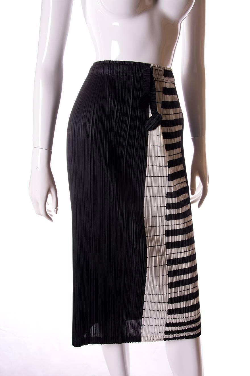 Skirt by Issey Miyake Pleats Please in a novelty piano print.  Mid calf length.  Ties at the waistband of the skirt are musical notes.  Signature pleated fabric.  Circa 90s.

Marked size – No marked size
To fit - S

Waist – 29-40 cm
Length –