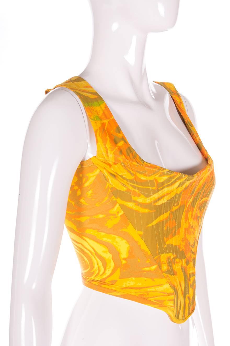 Boned corset top by Vivienne Westwood.  Photographic rose print in shades of yellow and orange.  Circa 90s.

Marked size UK 10
To fit S

Chest: 39-40 cm
Waist: 26-33 cm
Length: 42 cm

There is a degree of stretch in the fabric so our