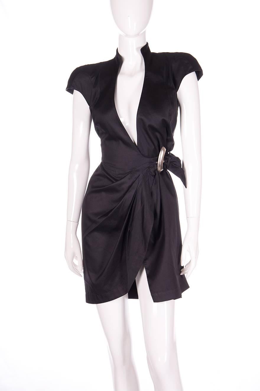 Wrap dress with a bold shoulder and accentuated waist by Thierry Mugler.  Sculpted shoulder pads.  Plunging deep v neck.  Oversized silver buckle at the waist.  Circa 80s.

No marked size
To fit XS-S

Waist: 32 cm
Chest: 41 cm
Length: 83