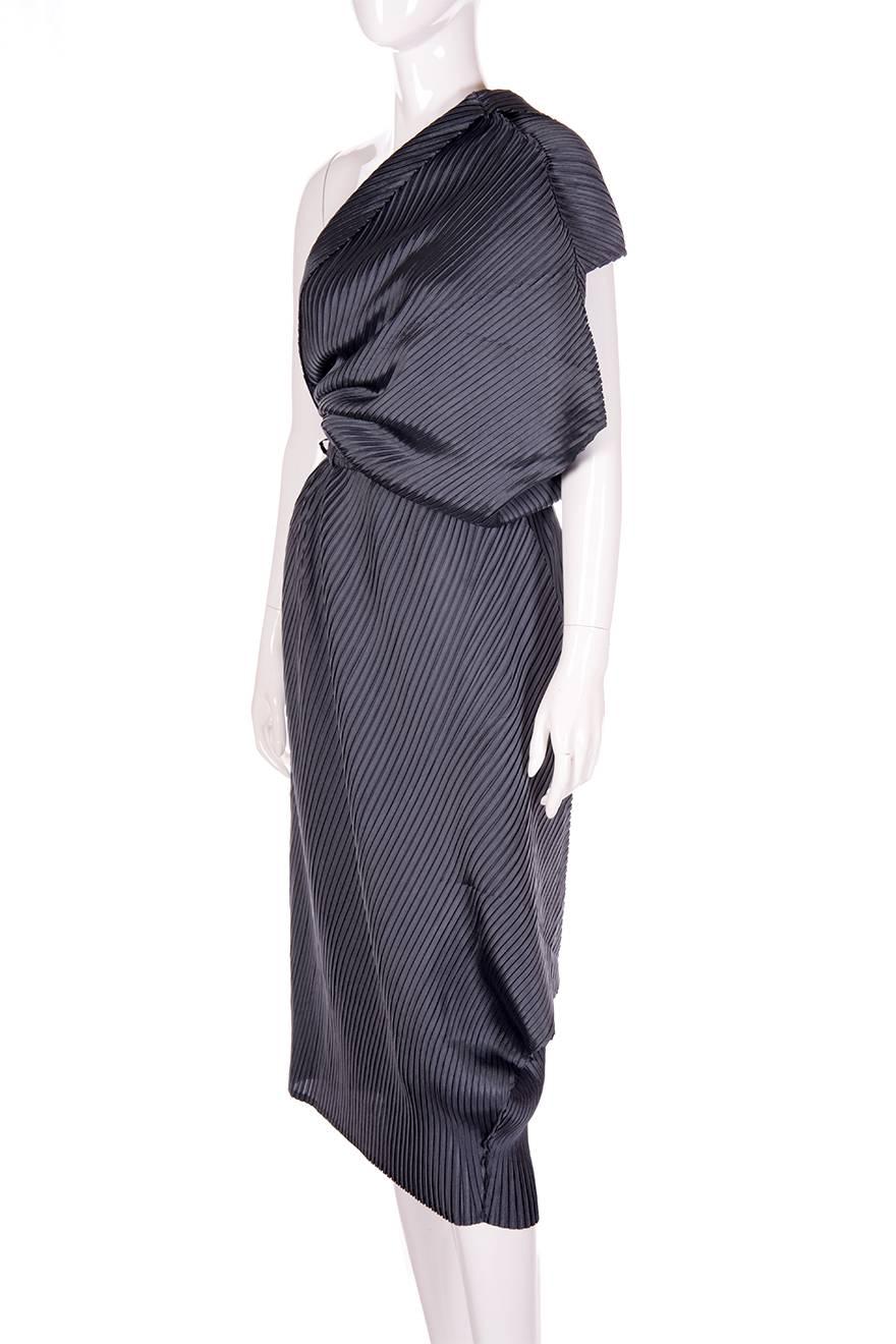 Elegant one shouldered dress by Issey Miyake.  This dress drapes beautifully on the body.  Pleated fabric.  Belted waist.  Circa 90s.  This dress is in a slightly lighter colour compared to our images; the fabric is a shade of gunmetal