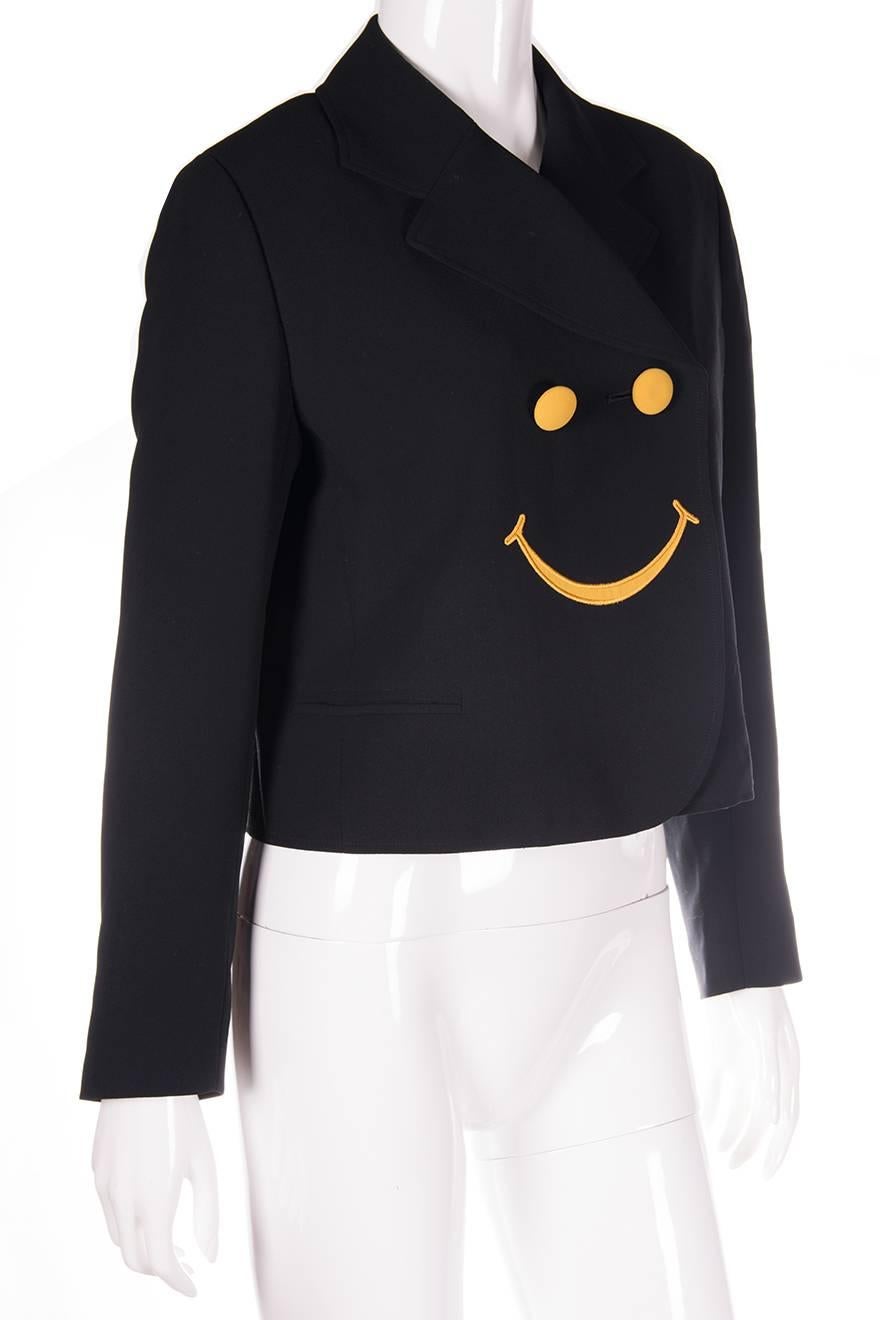 Cropped jacket by Moschino with a smiley face detail at the front.  Embroidered smiley mouth at the front of the jacket, with contrast yellow buttons at the front and on the sleeves.  Circa 90s.

Marked size: No marked size
To fit: M

Excellent