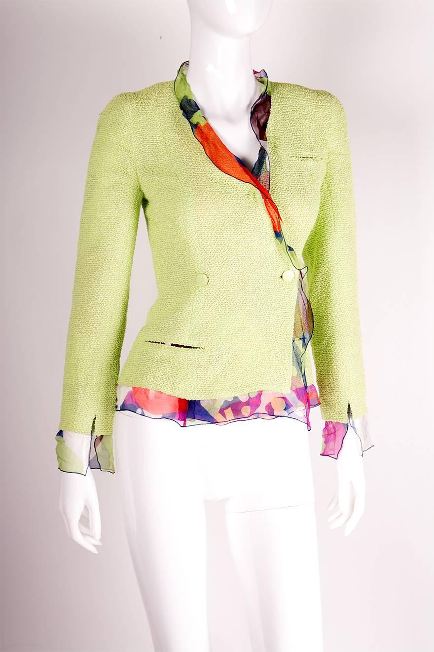 Double breasted blazer by Chanel in pale lime with a sheer camellia print trim around the sleeves and collar.  Circa 2000.  Signature Chanel CC buttons.

Marked size: 36 (FR)
To fit: S

Chest: 39 cm
Waist: 34 cm
Length: 54 cm
Sleeve (nape of