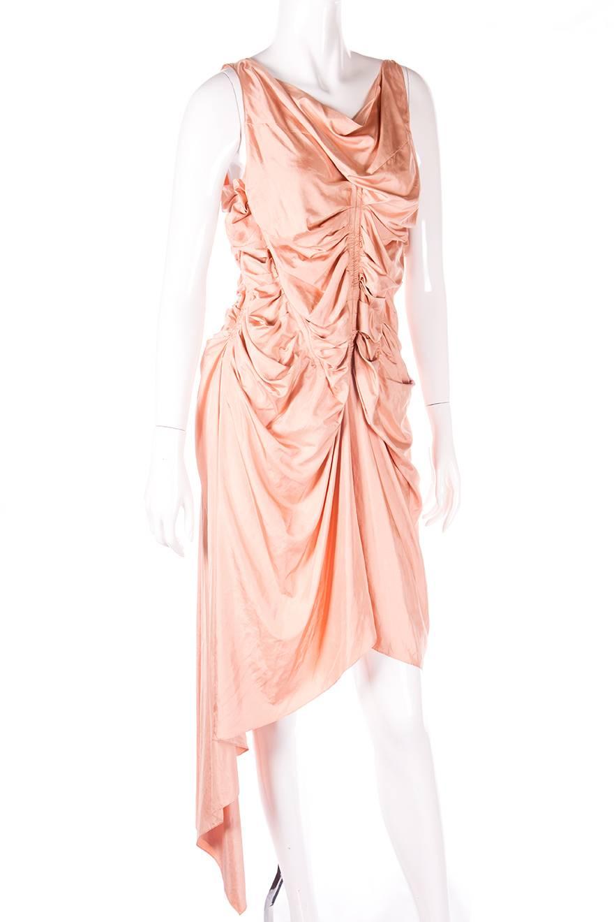 Salmon pink dress by Jean Paul Gaultier with an inbuilt corset/bodice and an asymmetrical hemline.  Circa 90s.

Marked size: 40 (IT)
To fit: S

Chest: 37 cm (unstretched)
Waist: 30 cm (unstretched)
Length: 89 cm (front of dress)
Please note