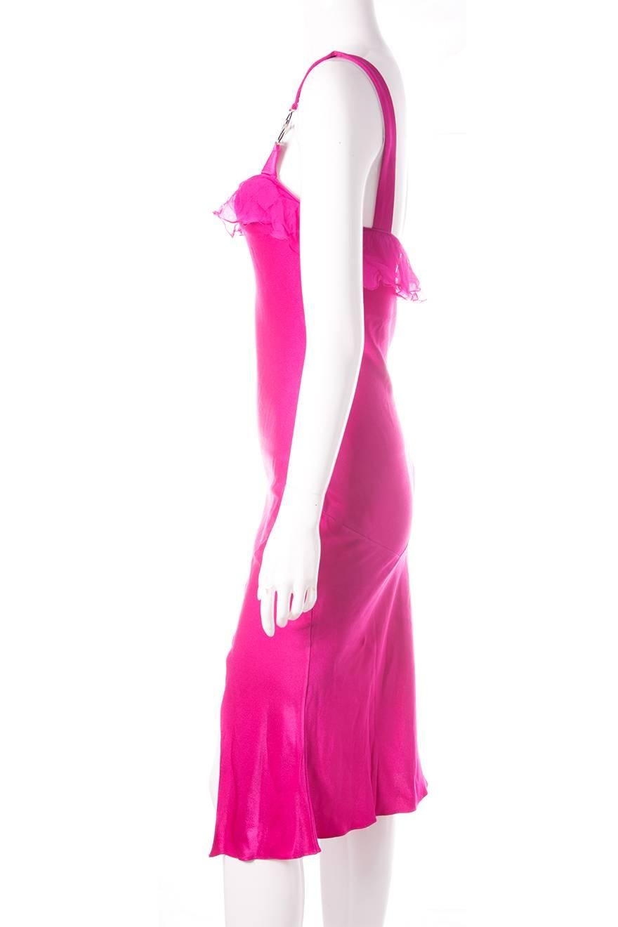 Fuchsia silk dress by Christian Dior featuring “Dior” metal detail on the straps. Ruffle neckline. Split hem. Circa early 00's.

Excellent condition demonstrating few visible signs of wear.

Marked size: 38 (FR)
To fit: S

Chest: 40 cm
Waist: 31