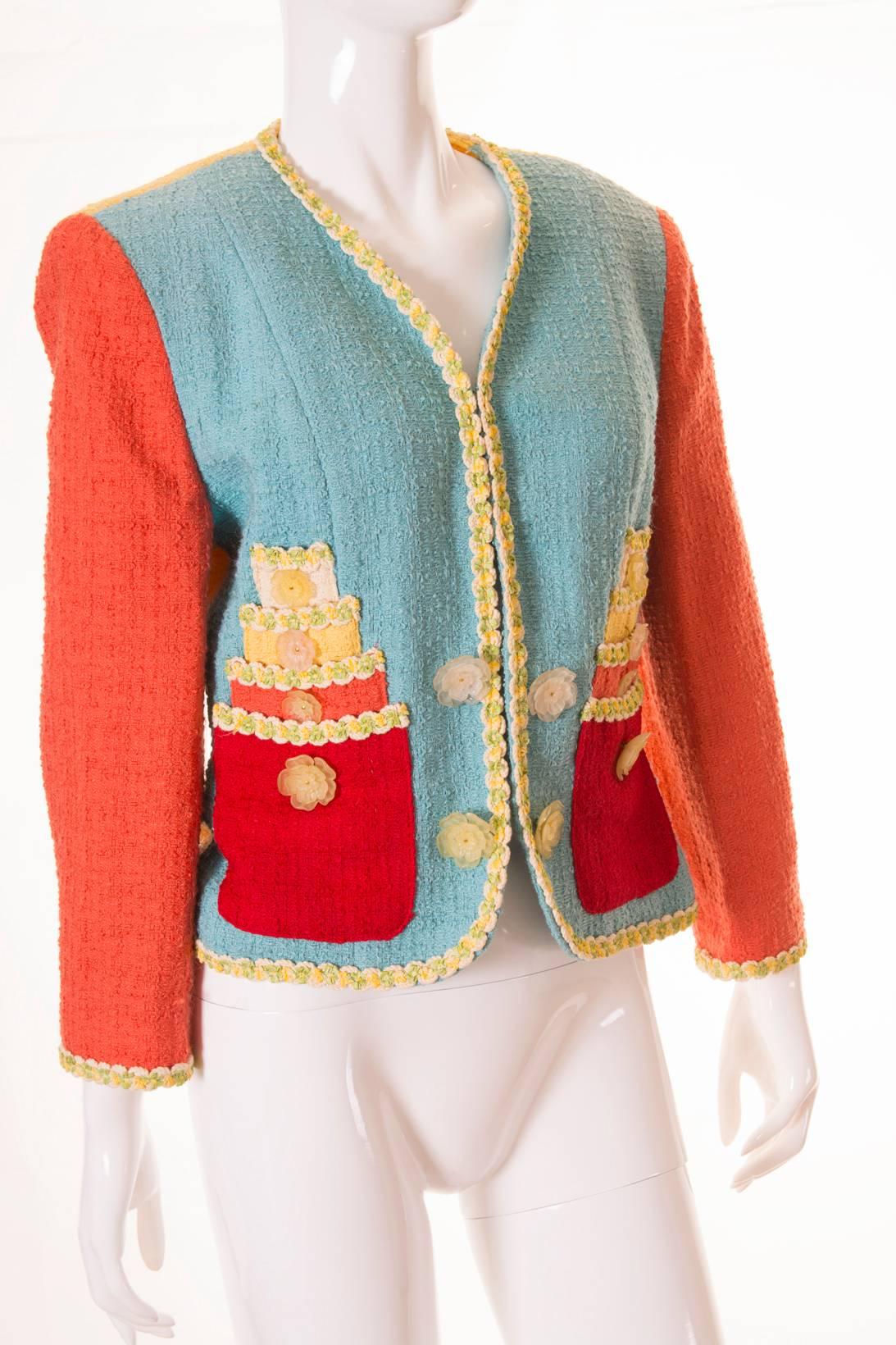 This Chanel-style Cheap and Chic jacket features the most adorable cake applique on the front. We love the boucle in contrasting pastel colours; pastel blue, coral, yellow and cream is offset with vibrant red. Frosted, novelty floral buttons at the