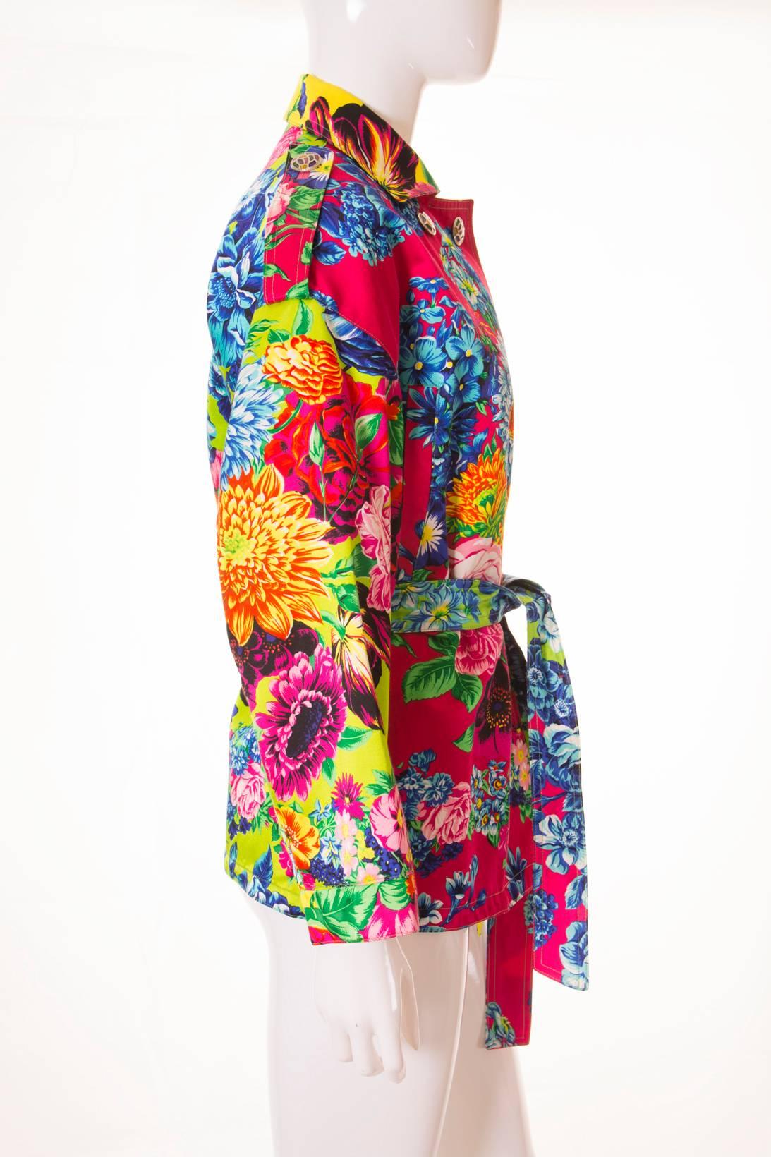 A truly lush jacket by Versus Versace. This jacket features a tropical inspired Hibiscus print in bright shades. We love the mix of acid yellow, lime green and magenta on this piece. The coat has a tie waist and multi coloured silver mosaic buttons.