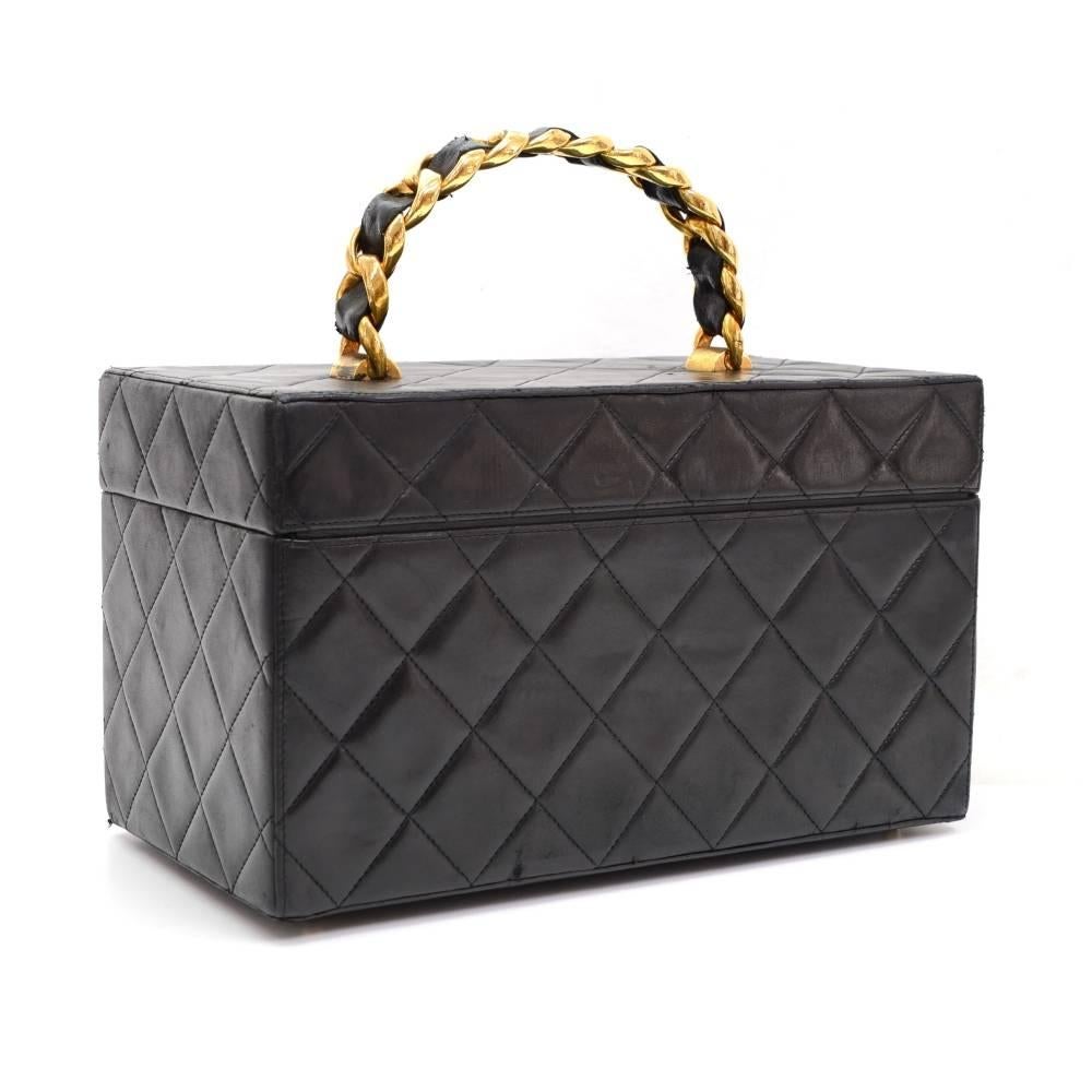 Chanel vanity large cosmetic bag in black quilted leather. Top is secured with flap and CC logo twist lock. Inside is in famous Chanel red lambskin lining with mirror on flap, 4 open pockets. Carried in hand. Simple and functional. 
Made in: