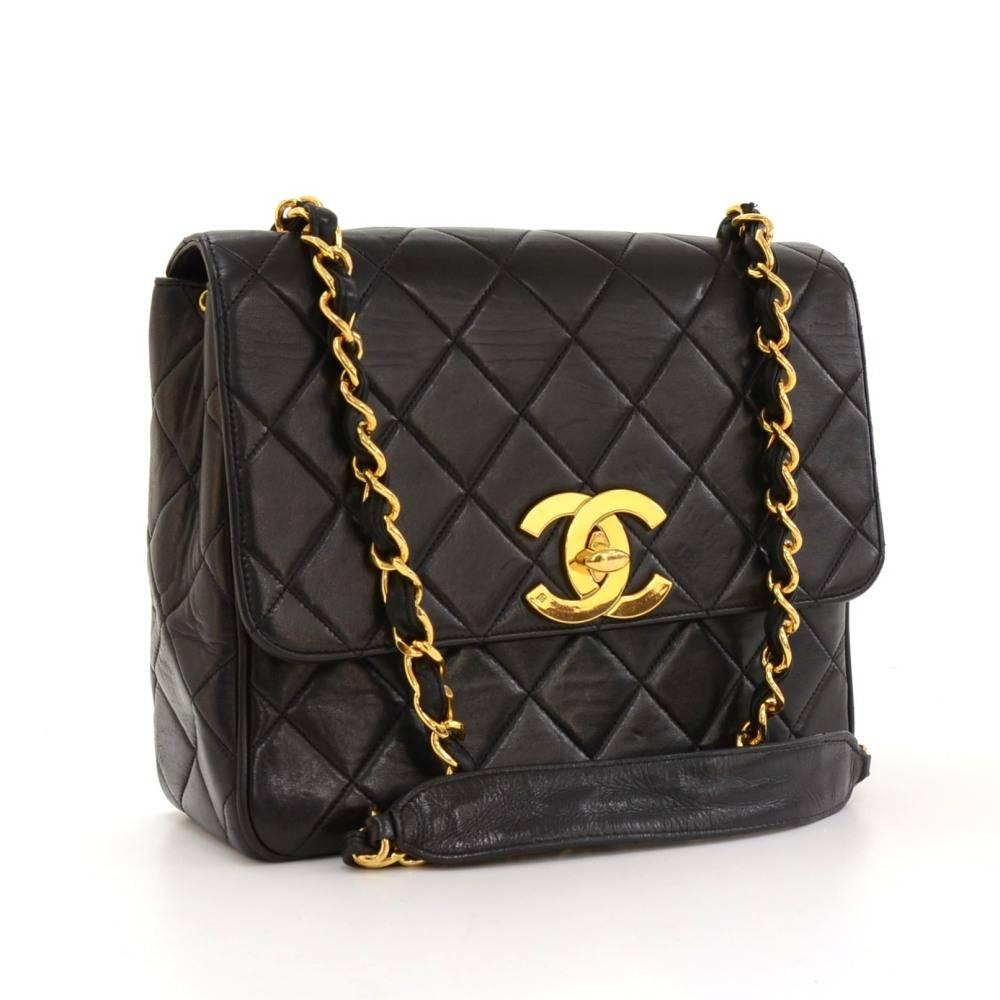 Chanel Black quilted leather shoulder bag. It has a flap with large CC twist closure on the front and 1 exterior open pocket on back. Inside has Chanel red leather lining with 1 zipper pocket and 1 open pocket. It can be carried on shoulder or