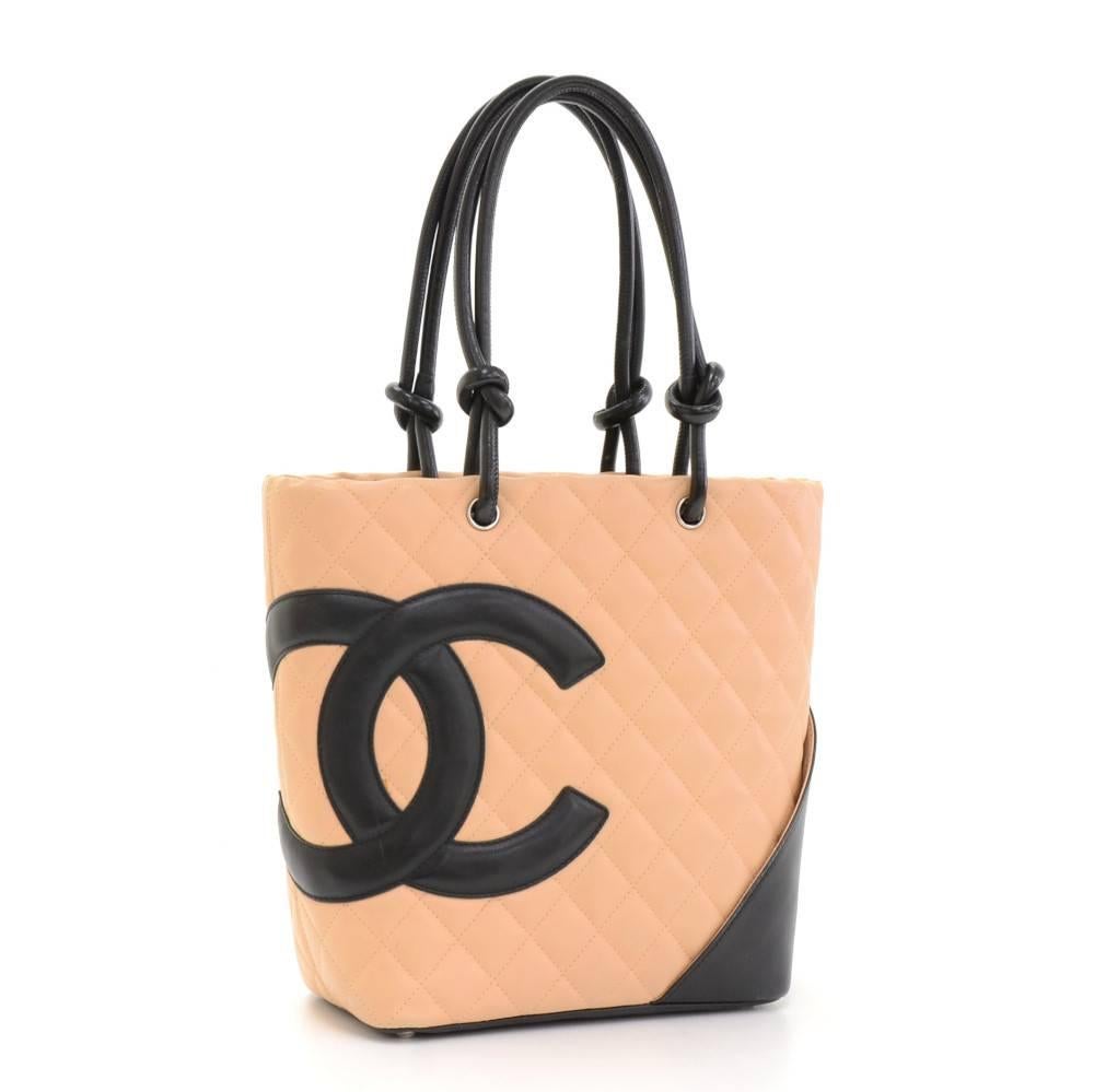 Vintage Chanel tote bag in beige x black quilted leather. Main access is secured with zipper. Inside is black fabric lining with 2 zipper pockets. Comforatbly carried in hand. Perfect for daily use.

Made in: France
Serial Number: 8809263
Size: