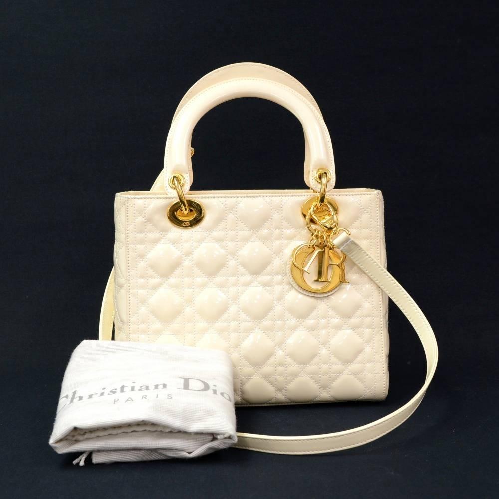 Christian Dior Lady Dior hand bag in white quilted cannage leather. Main access is secured with zipper. Inside has 1 zipper pocket and red fabric lining. Comfortably carried in hand or on shoulder with additional strap.

Made in: Italy
Serial