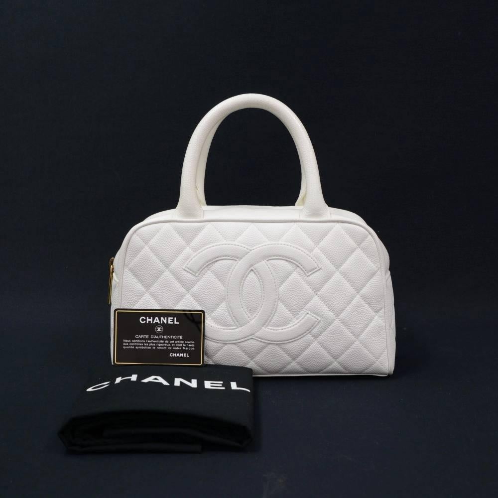 Chanel Mini Boston hand bag in white quilted caviar leather. Outside has 1 open pocket on back. Main area is secured with zipper. Inside has white textile lining with 1 zipper pocket. Great companion where you go.

Made in: France
Serial Number: