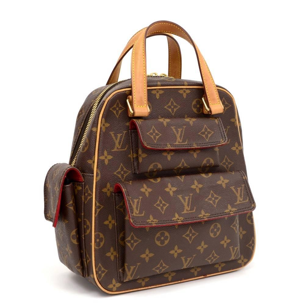 Louis Vuitton Excentri cite Bag in monogram canvas. Secured with a double zipper closure. Outside has 3 flap pockets with magnetic closure. Inside has 1 open pocket and red alkantra lining. Comfortably carried in hand. 

Made in: France
Serial