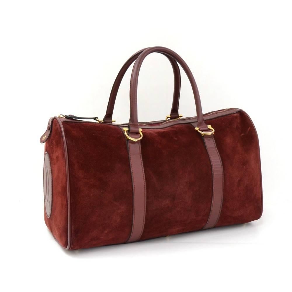 Les Must de Cartier boston bag in red wine suede leather. Main area is secured with zipper. Inside has matching textile lining and zipper pocket. It would make a great presence wherever you go

Made in: France
Size: 16.5 x 9.8 x 8.3 inches or 42